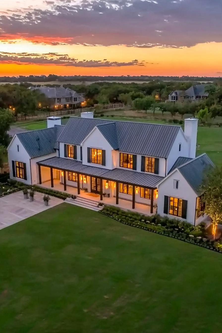 Spacious farmhouse with a large veranda at dusk