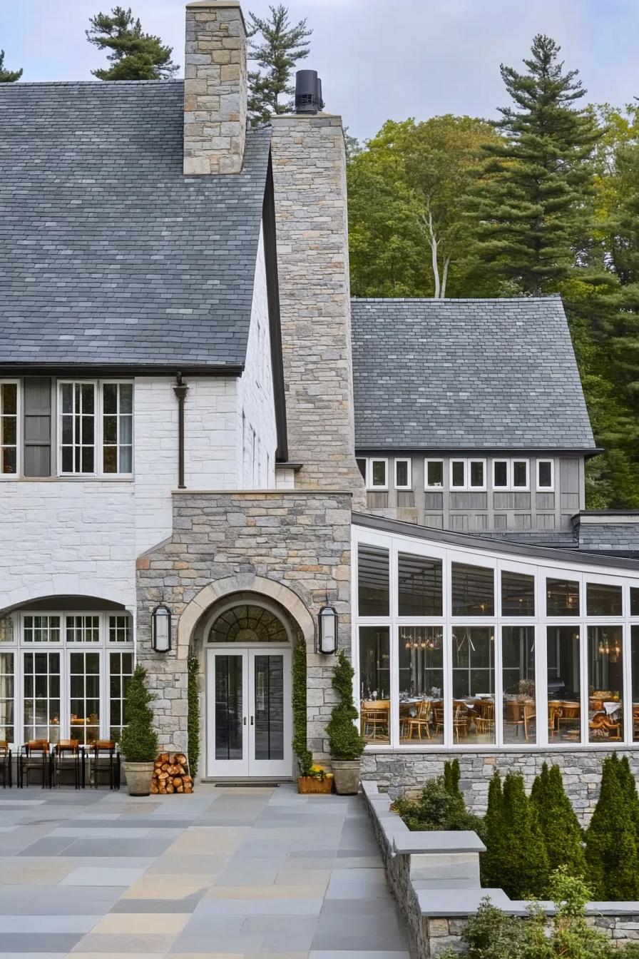 Stone house with large windows and lush greenery