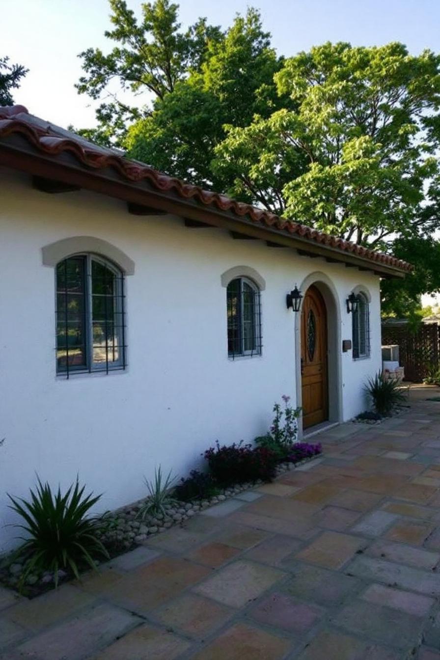 White cottage with arched windows and terracotta roof