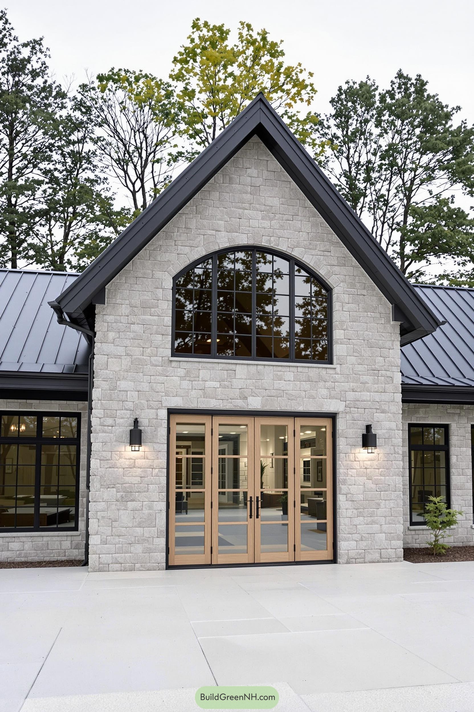 Stone farmhouse with modern black-framed windows and wooden doors