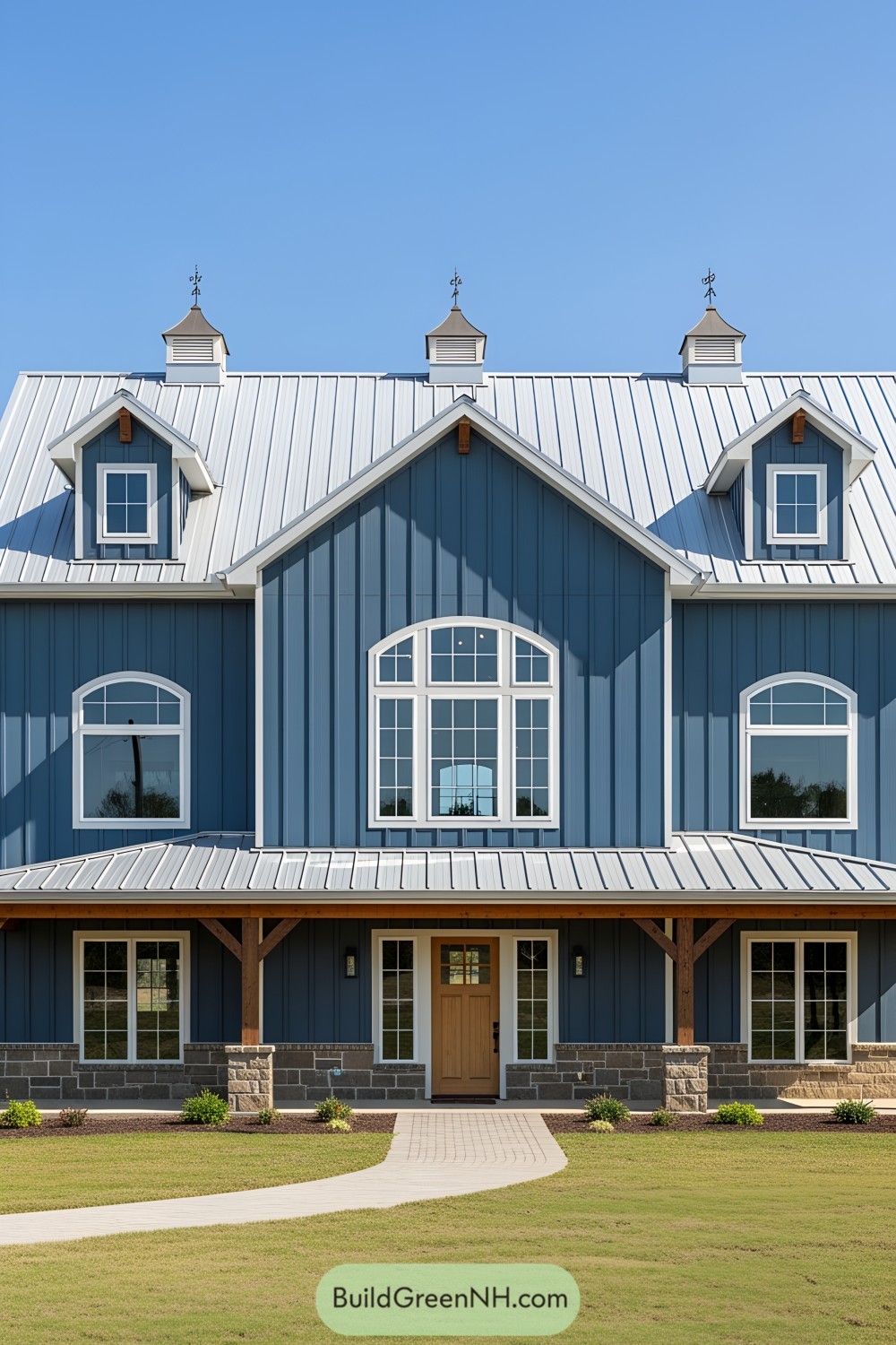 Blue farmhouse with white accents and metal roof