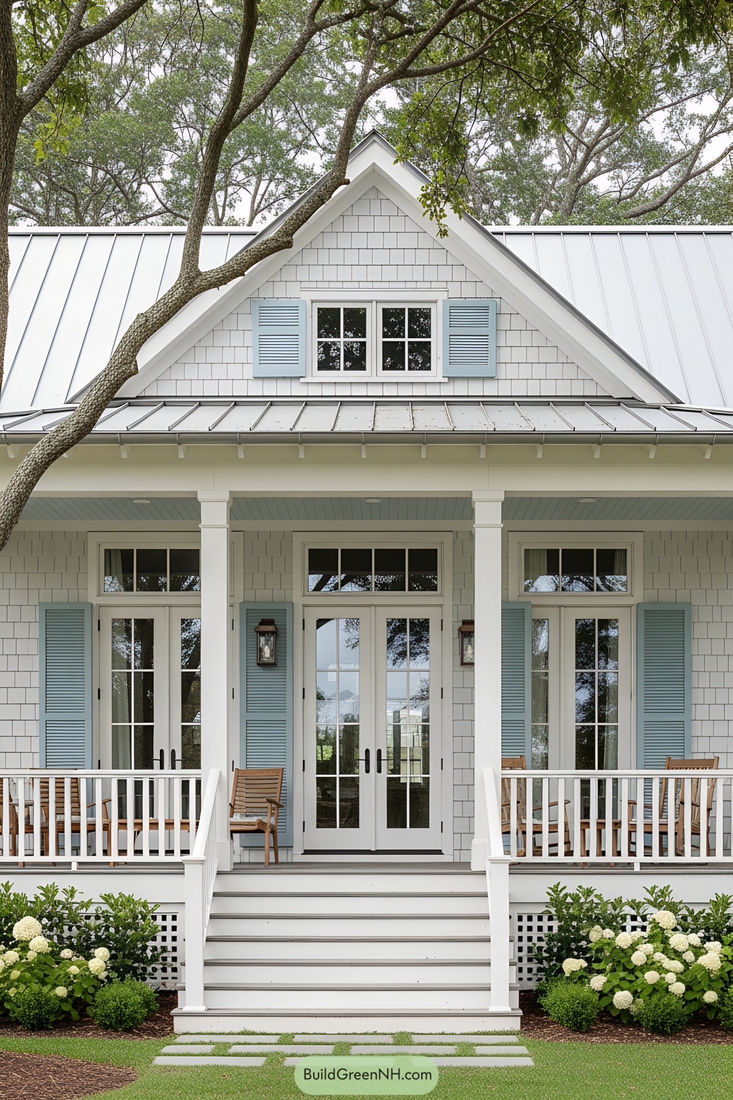 White bungalow with blue shutters and lush greenery