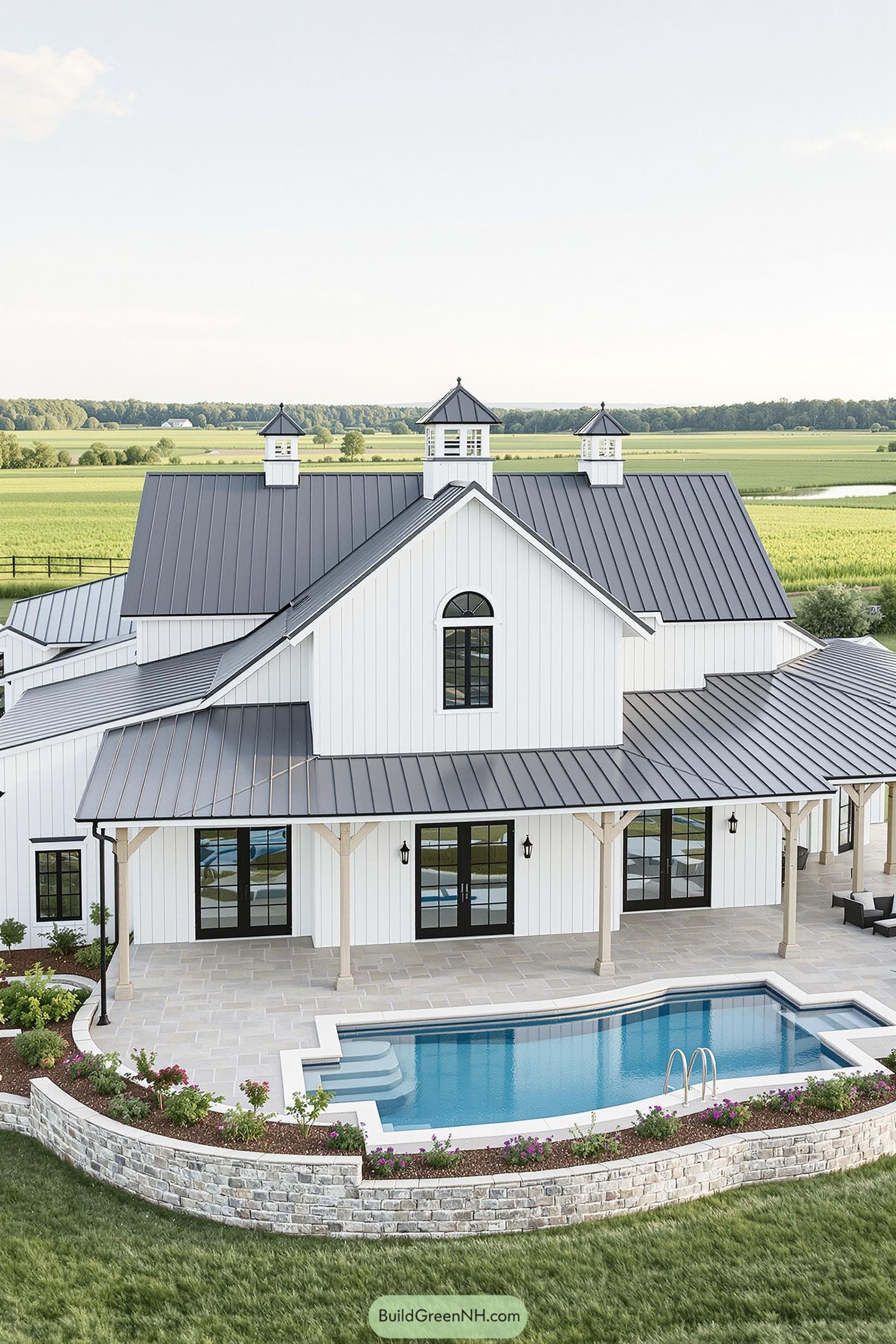 Stylish white barndominium with a pool and countryside backdrop