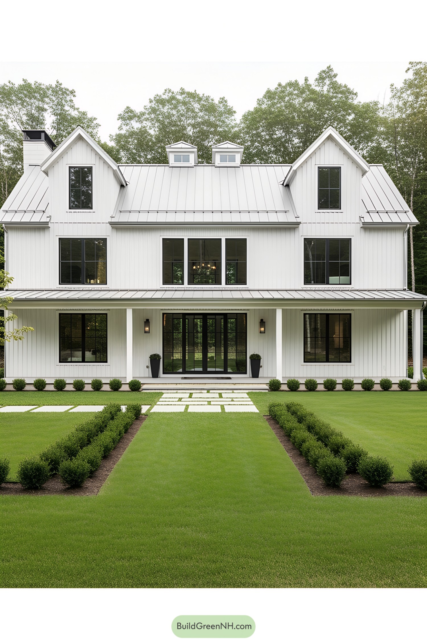 White barn house with manicured lawn and big windows