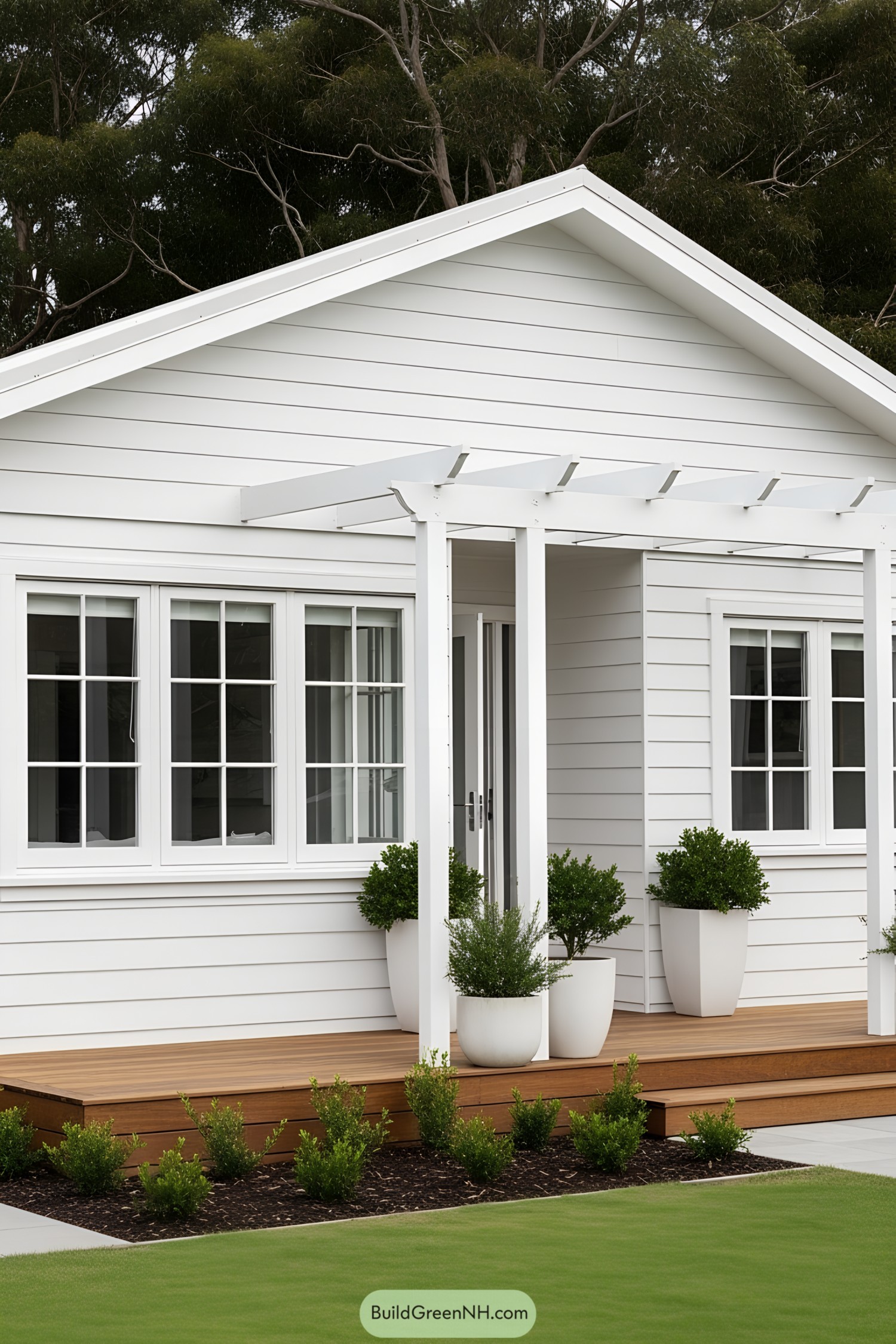 White bungalow with a wooden porch and potted plants