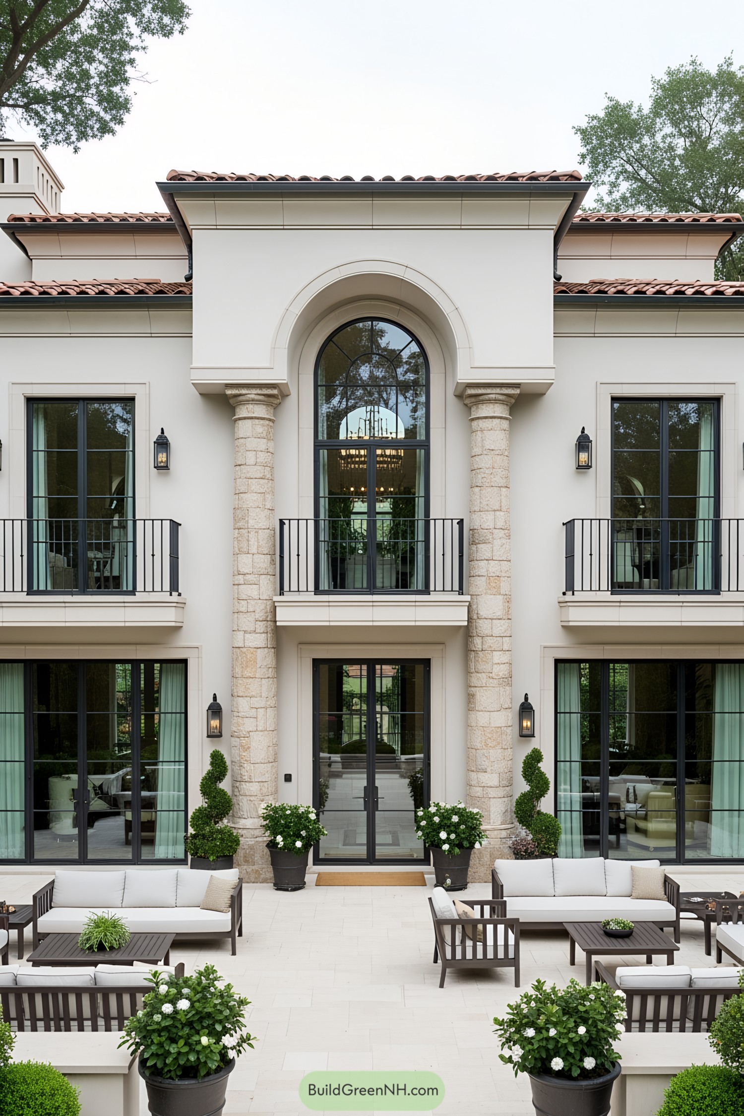 Elegant luxury villa with stone columns and lush courtyard