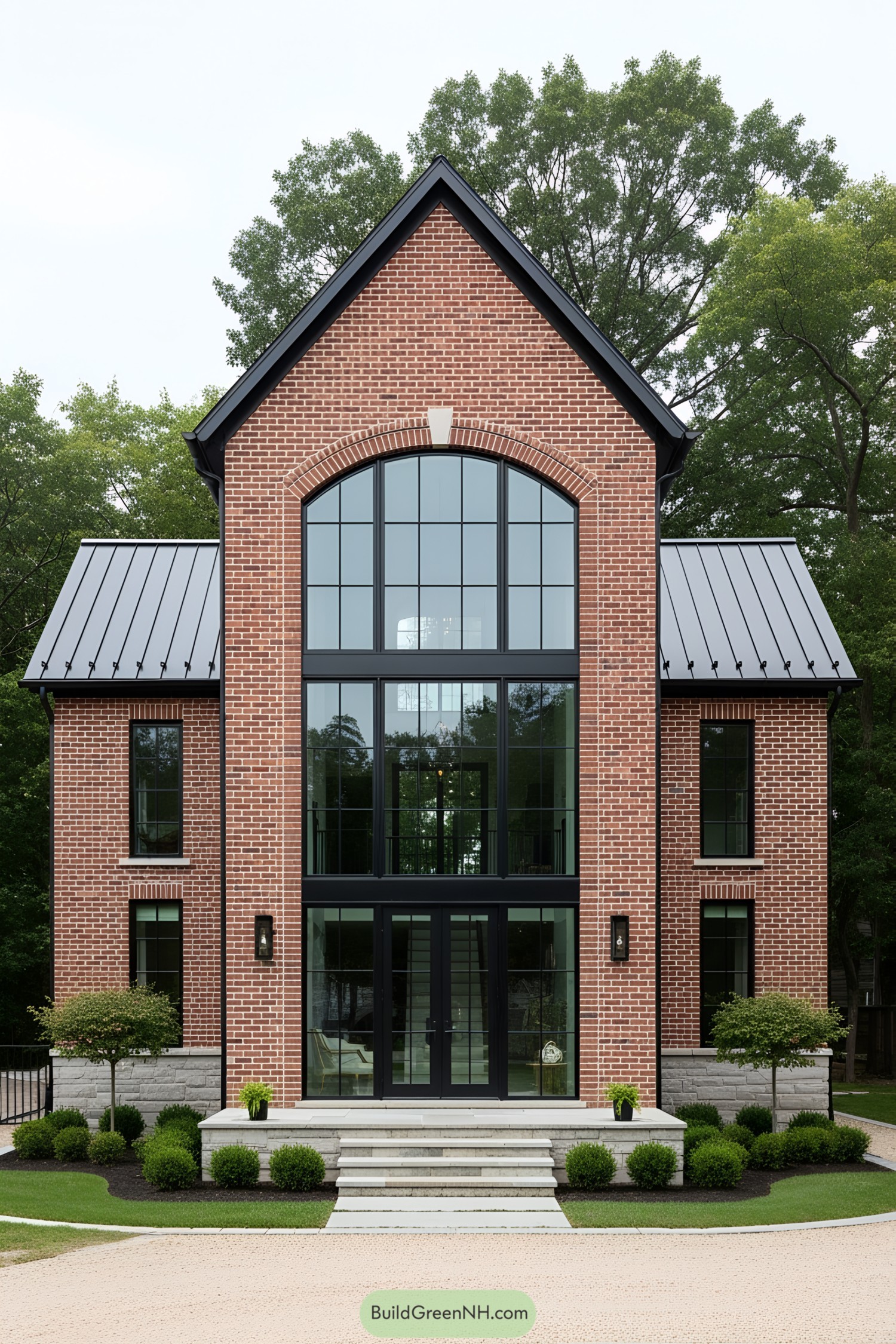 Red brick house with large arched windows and metal roofing