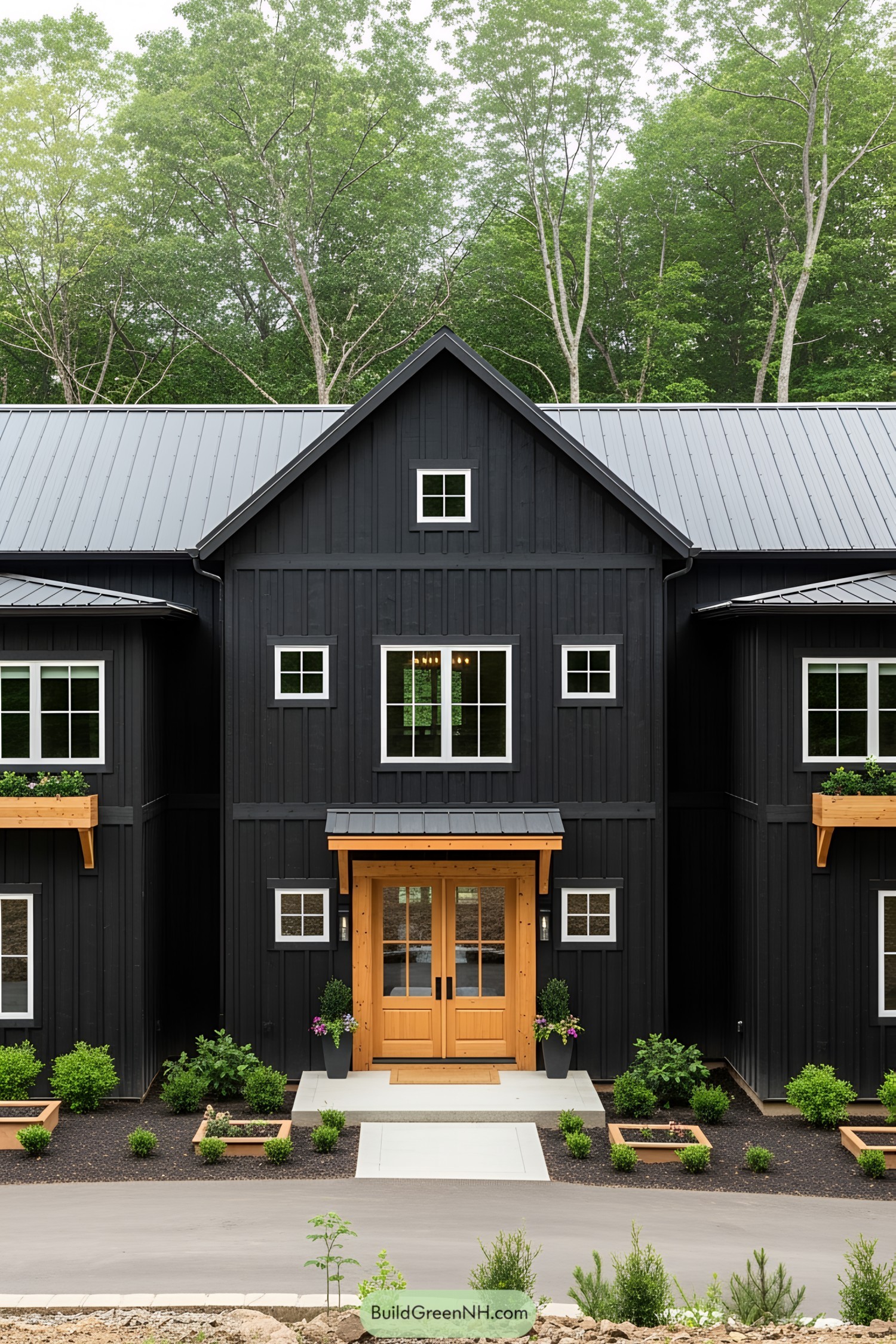 Black pole barn house with a wooden door and charming windows