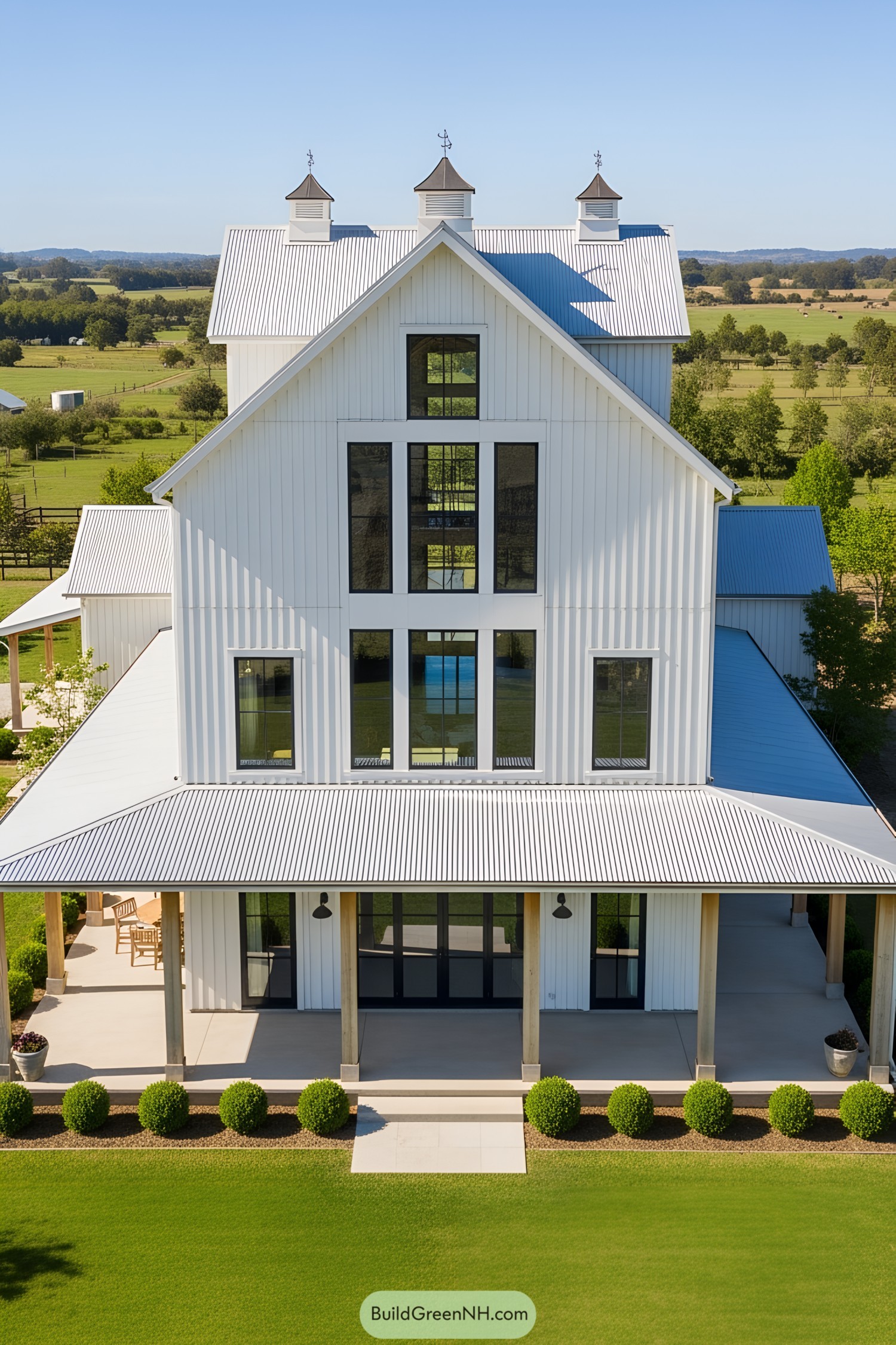 White barn house with cupolas and large windows