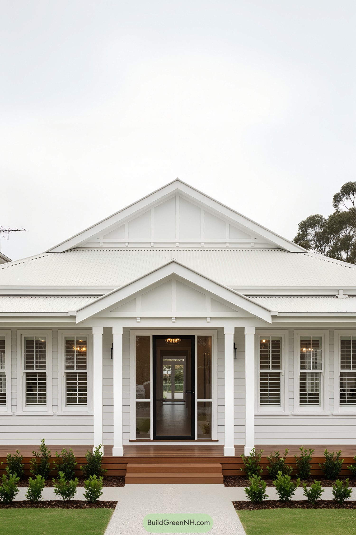 Crisp white bungalow with a cozy porch and vibrant greenery