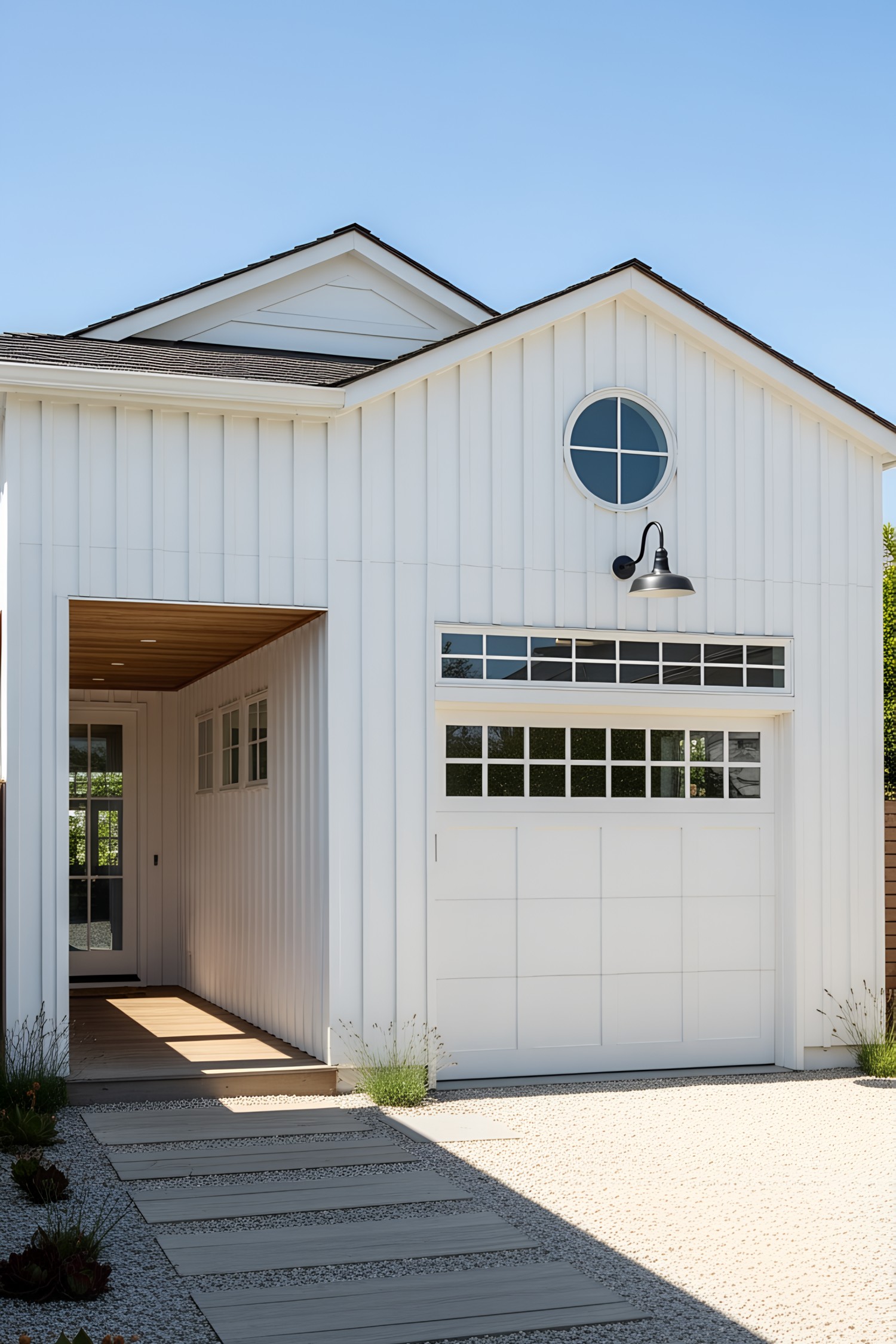 Modern white coastal home with large garage door and pathway
