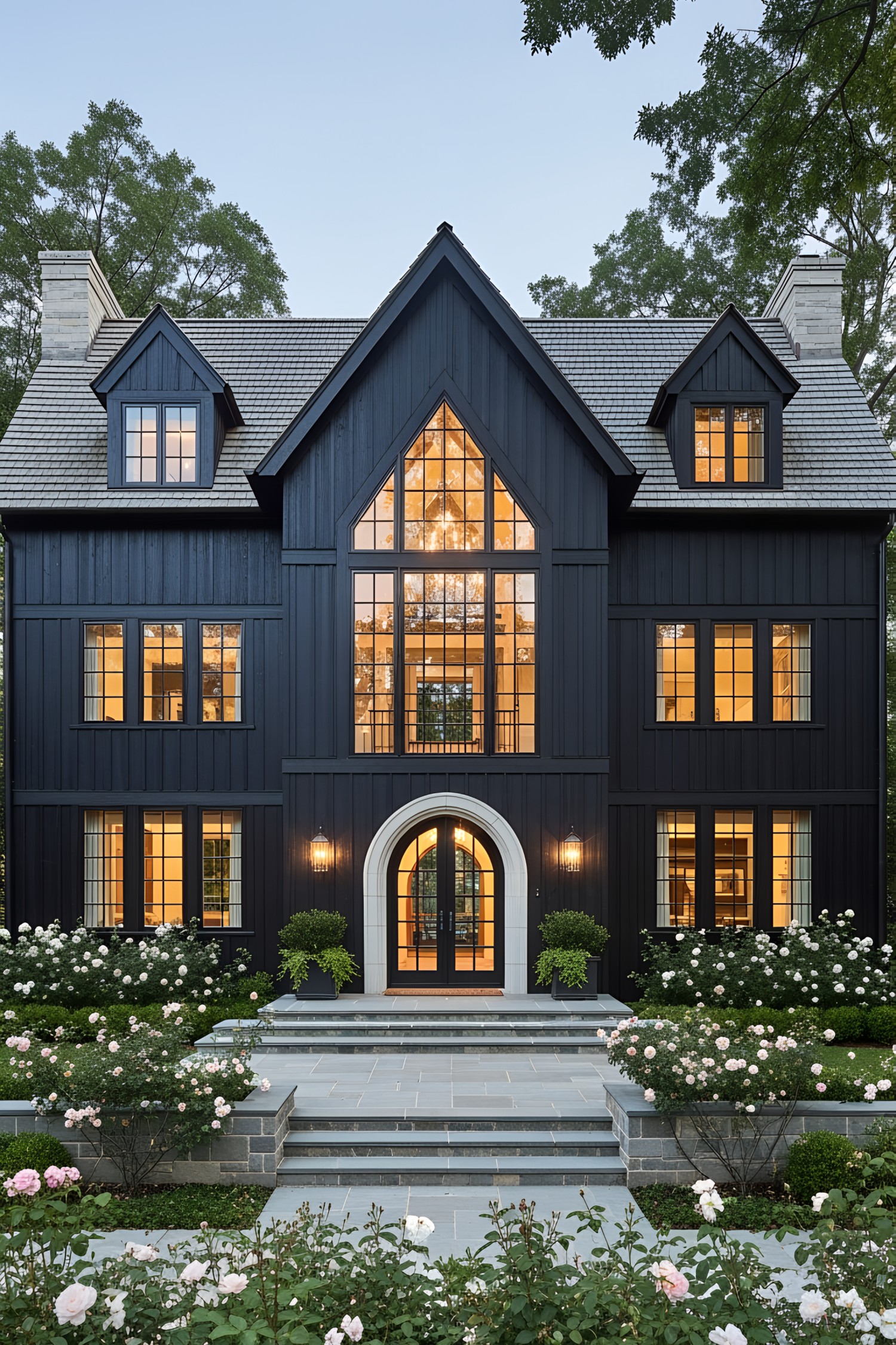 Dark coastal house with large windows and manicured garden
