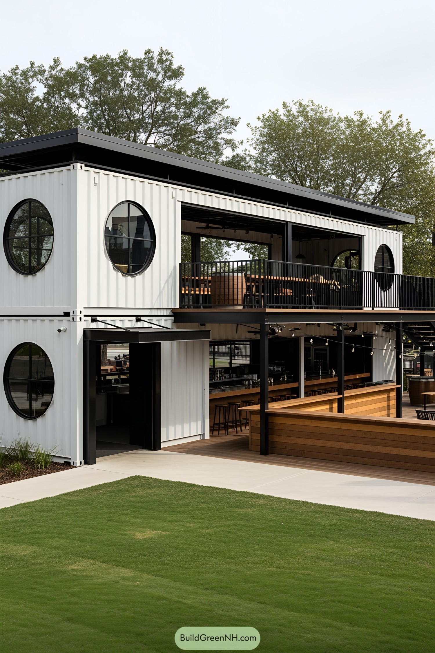 Two-story white container bar with circular windows and outdoor seating