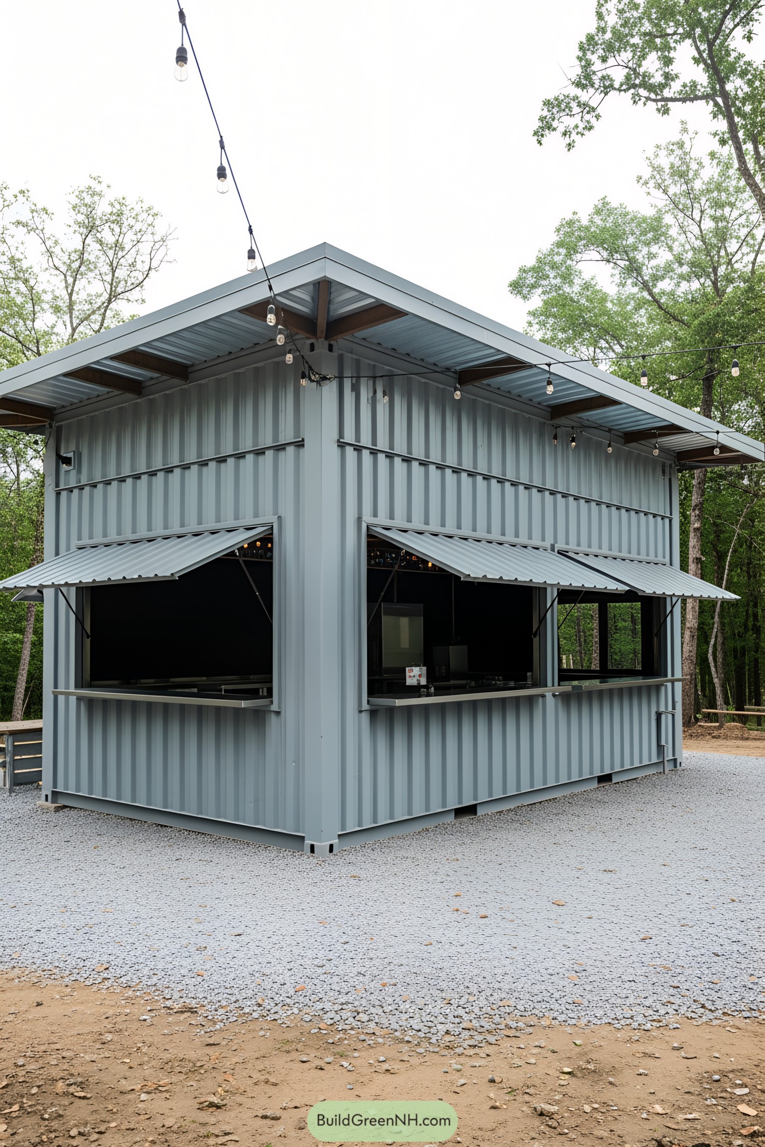 A gray container bar surrounded by trees and string lights