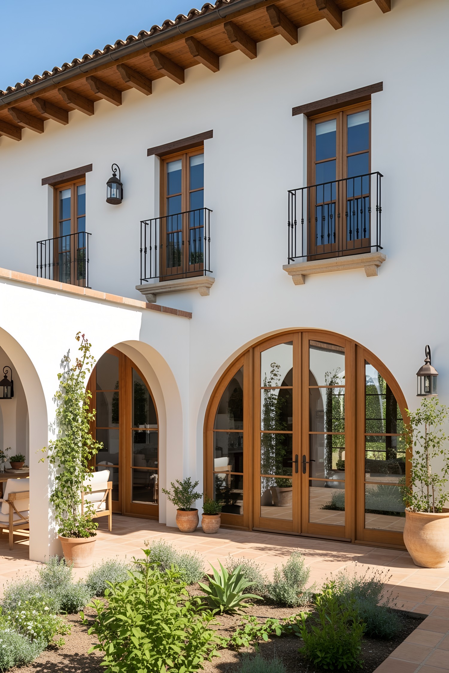 Contemporary Spanish farmhouse with wooden arched doors and balconies