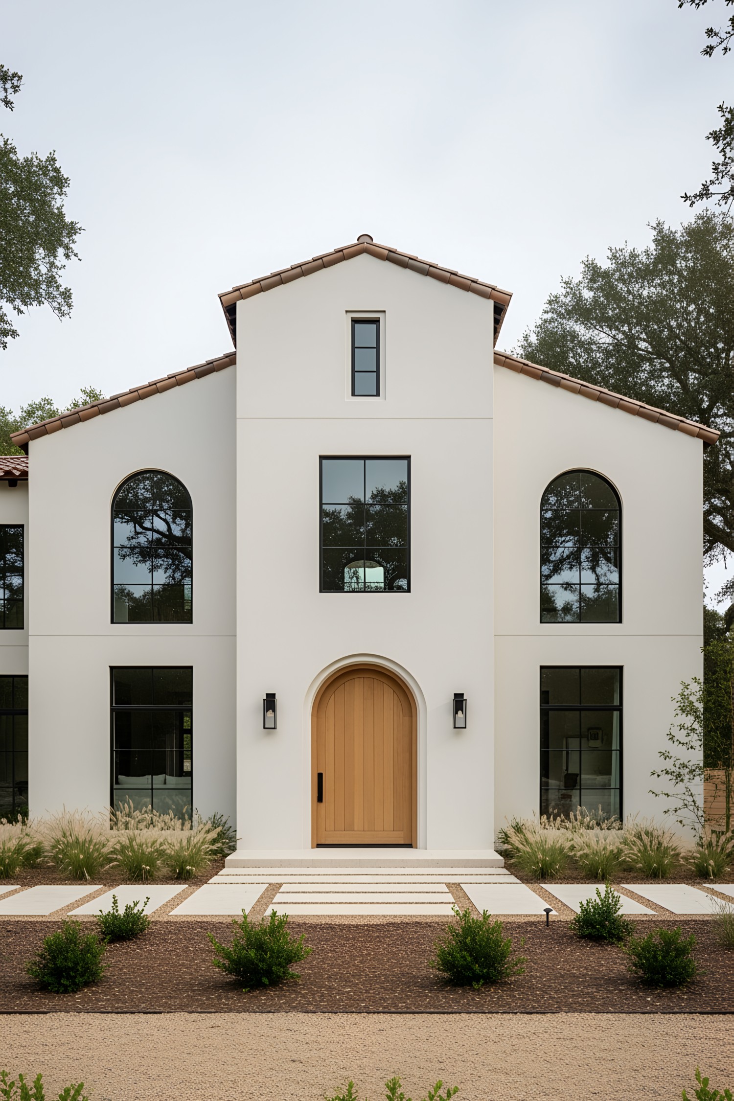 Elegant modern farmhouse with arched windows and central wooden door
