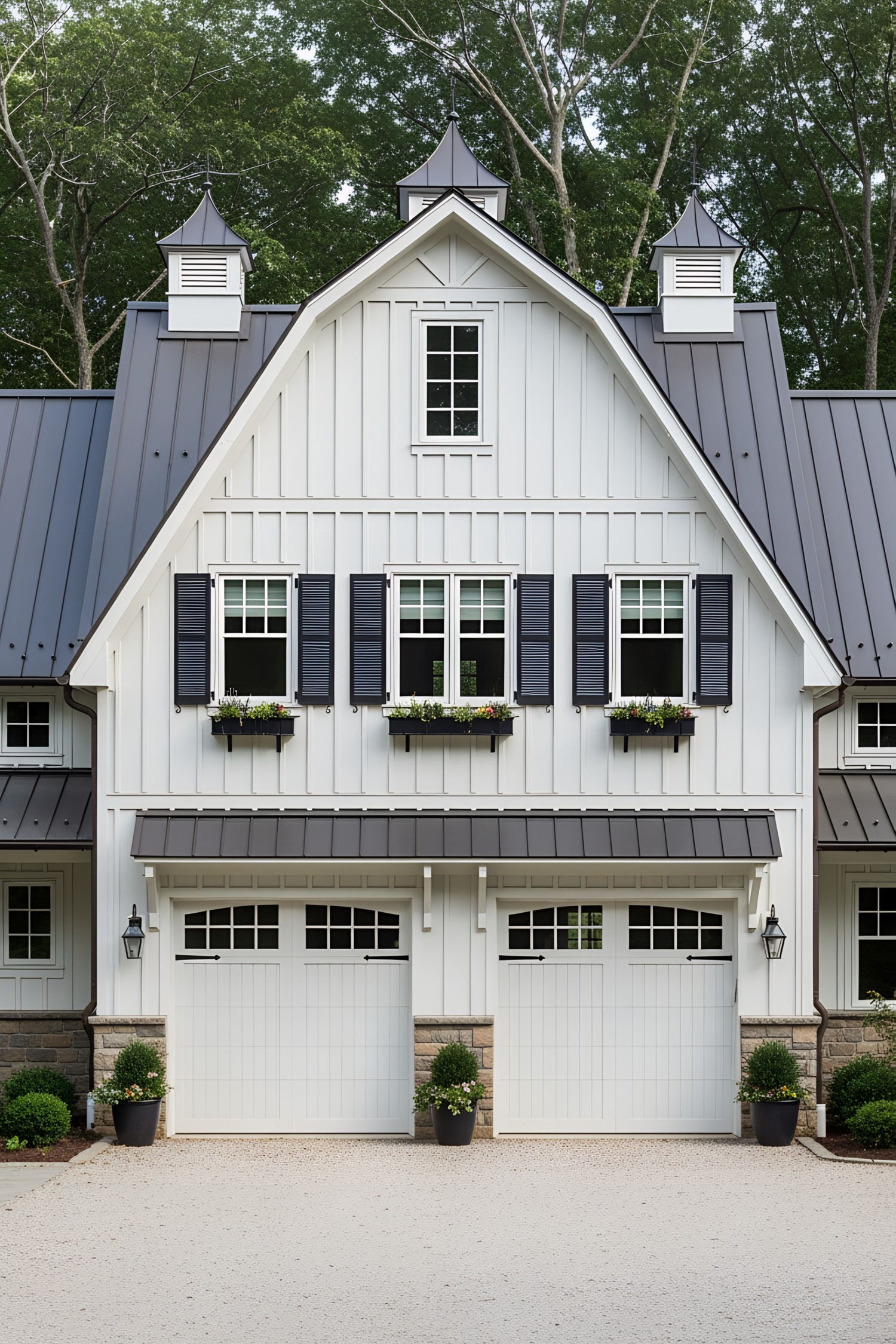 White farmhouse with large garage and black shutters