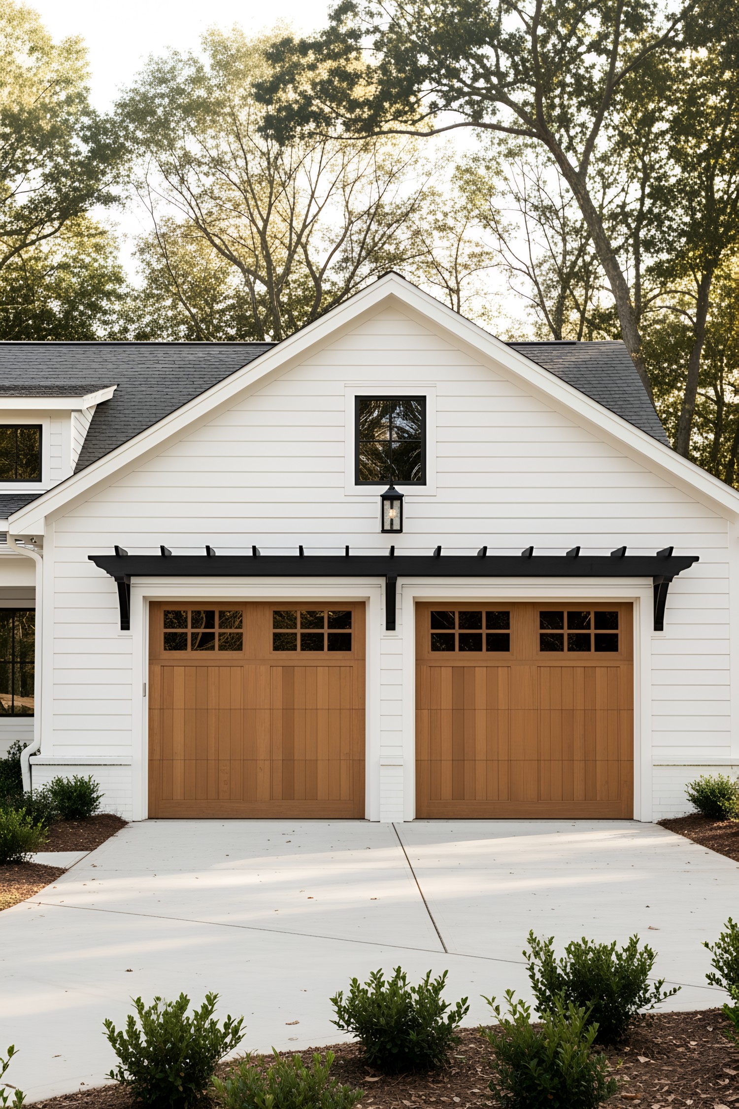 White farmhouse with twin wooden garage doors