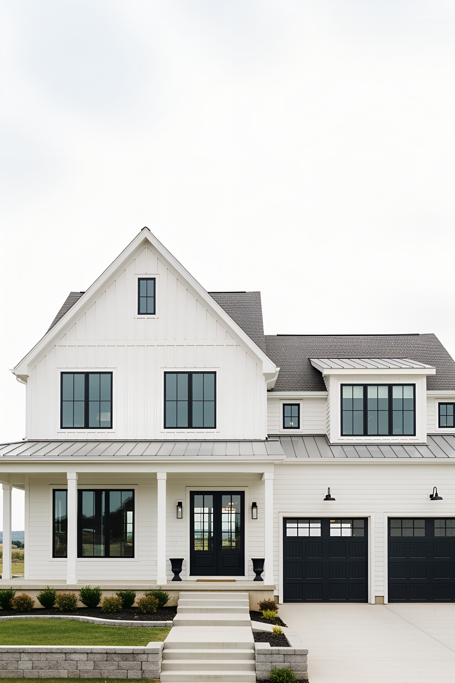 White farmhouse with black garage doors and clean landscaping