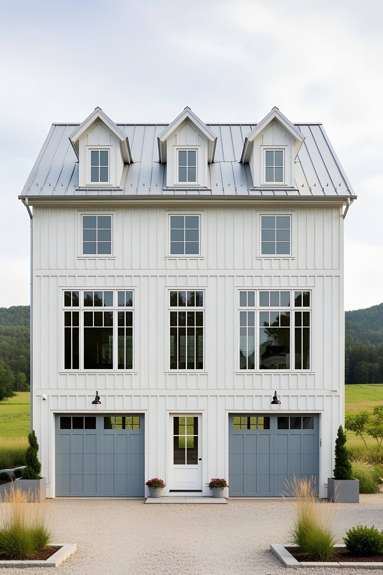 White farmhouse with blue garage doors and lush greenery