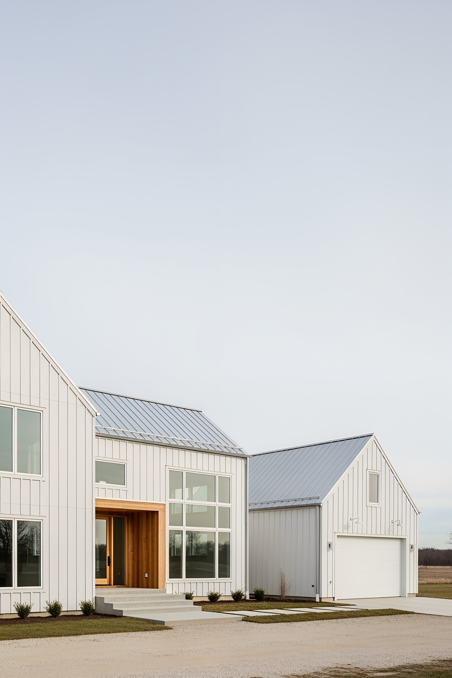 White farmhouse with a metal roof and attached garage