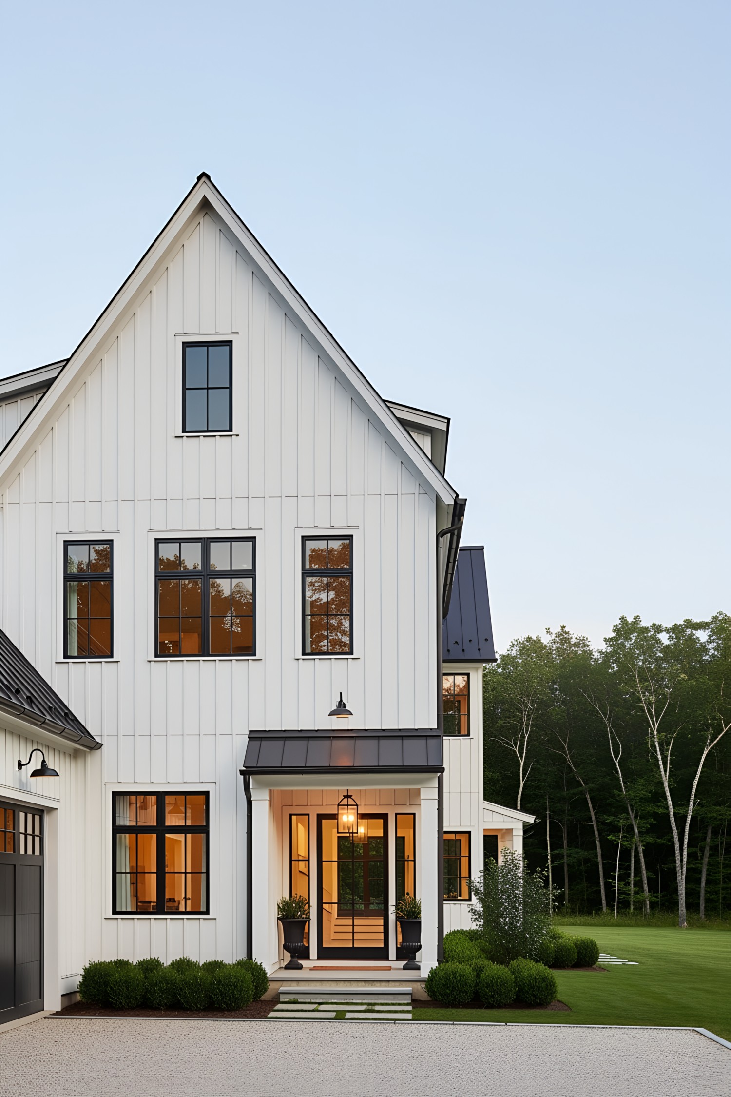 White farmhouse with black-trimmed windows and matching garage