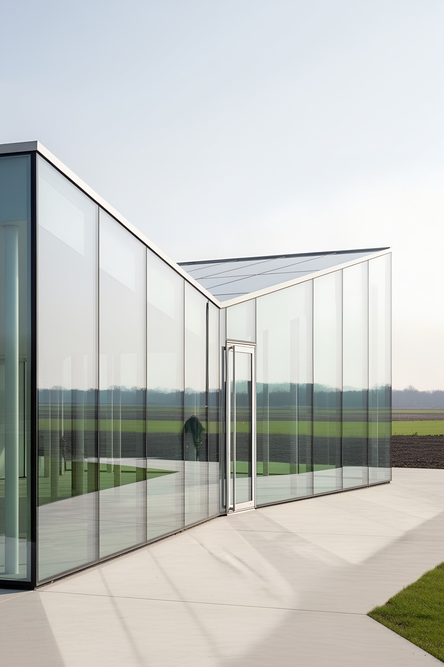 Modern glass pavilion set in a rural landscape