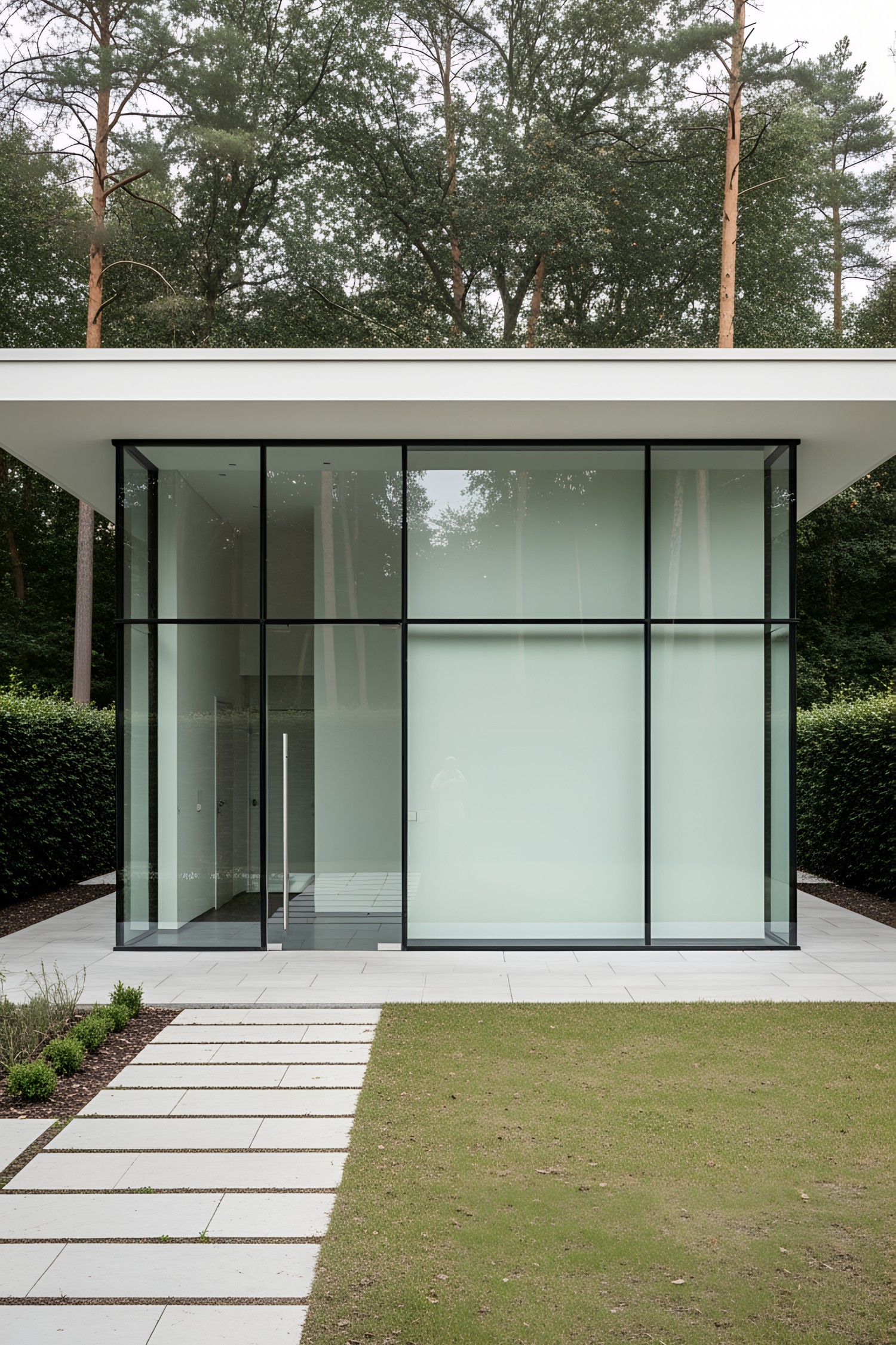 Modern glass pavilion surrounded by trees