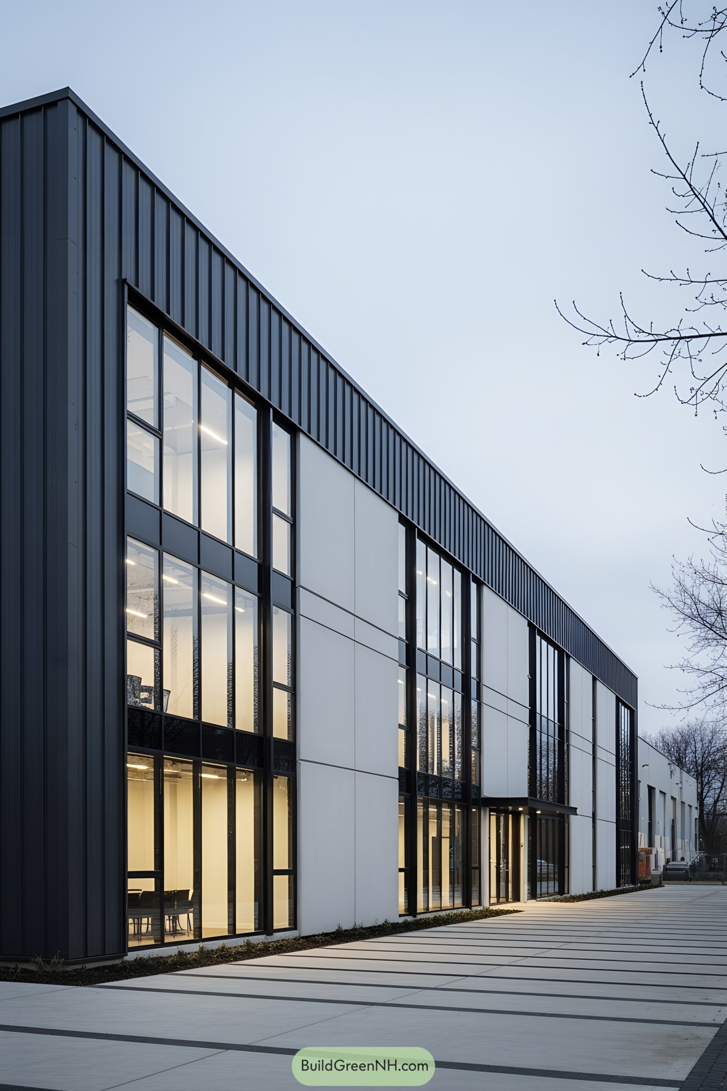 Modern industrial building with a sleek facade, featuring large vertical windows and a combination of dark panels and light surfaces