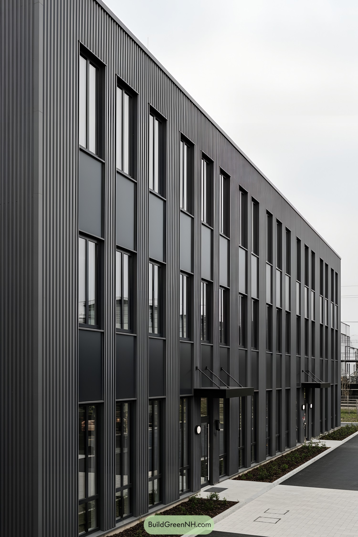 Modern industrial building with tall, sleek windows and ridged metal facade