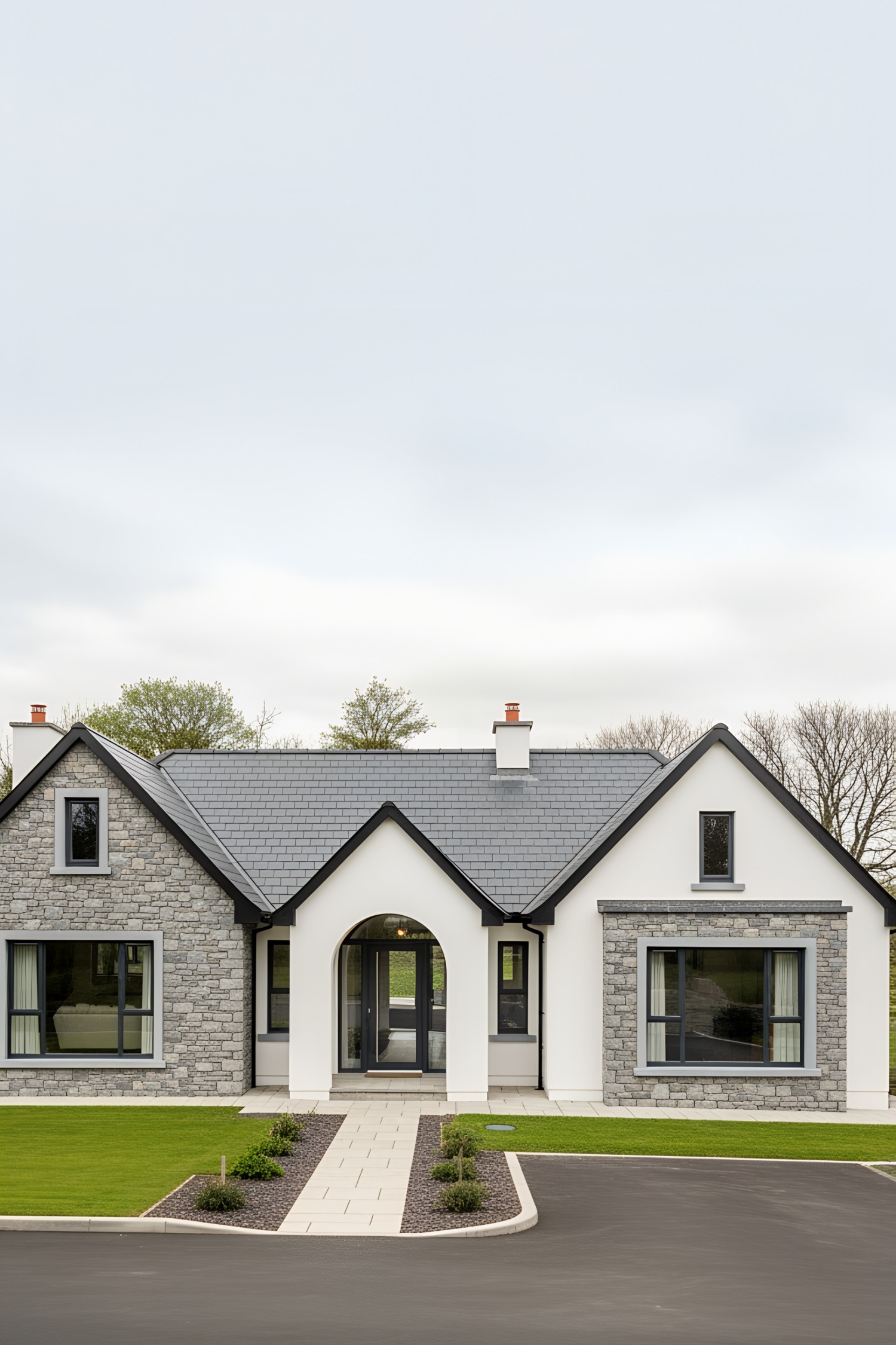 Whitewashed Irish bungalow with stone accents and manicured lawn