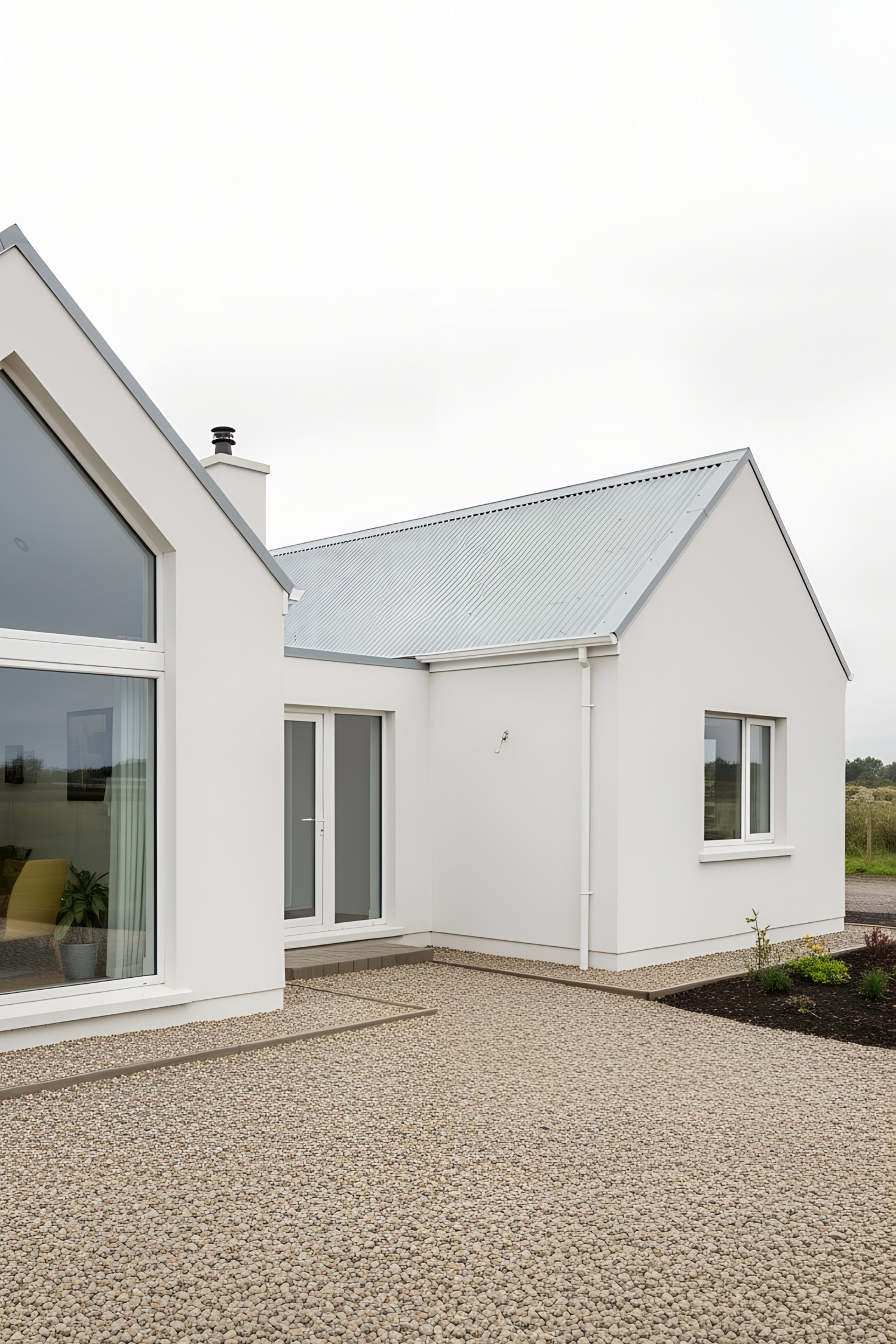 Modern white bungalow with glass doors and pebbled path