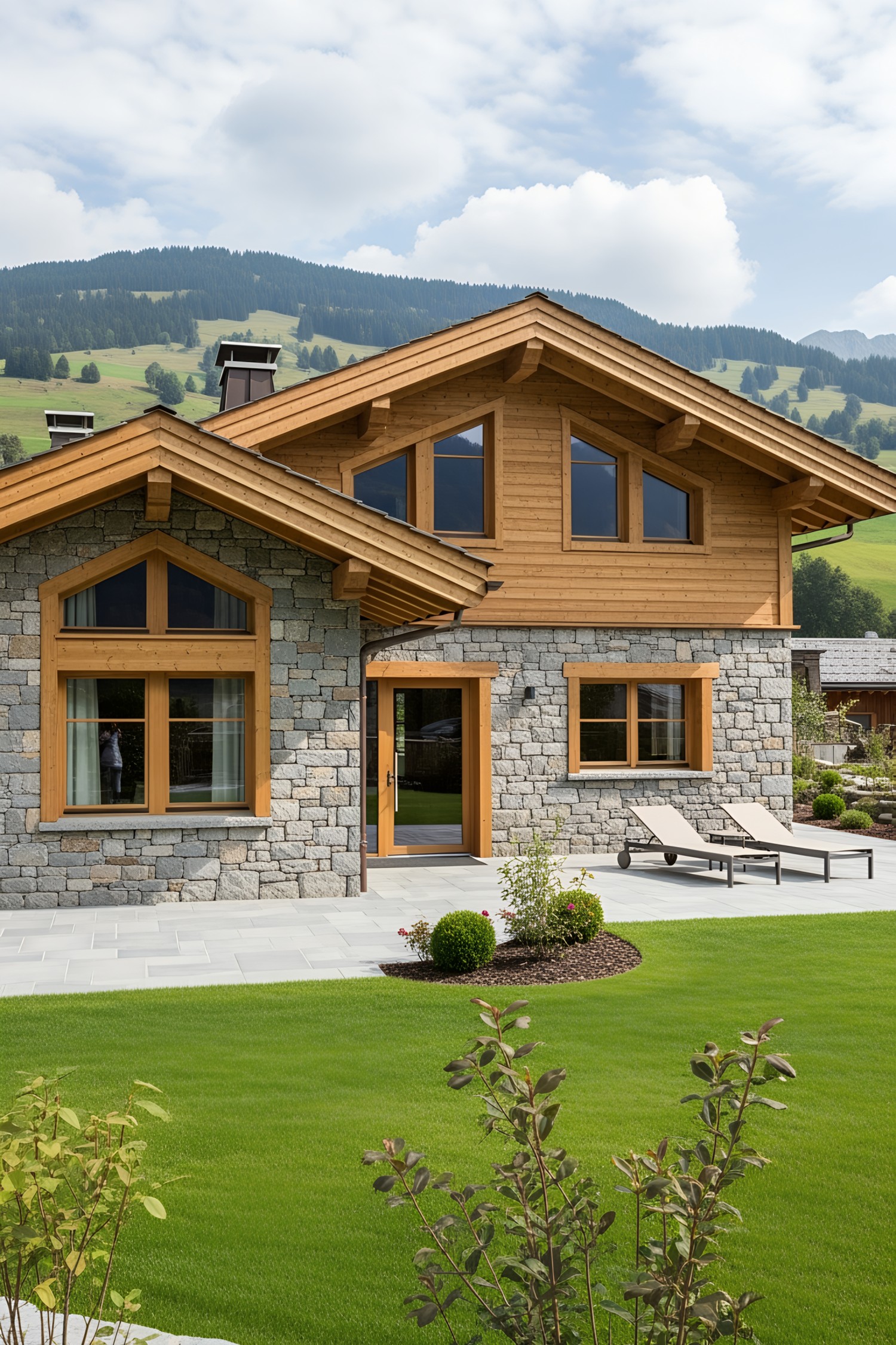 Chalet with stone facade and wooden accents surrounded by lush greenery