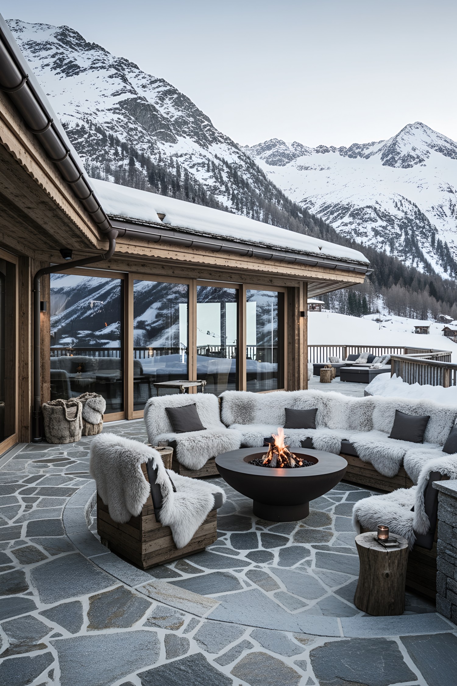 Cozy outdoor seating around a fire pit with snowy mountains in the background