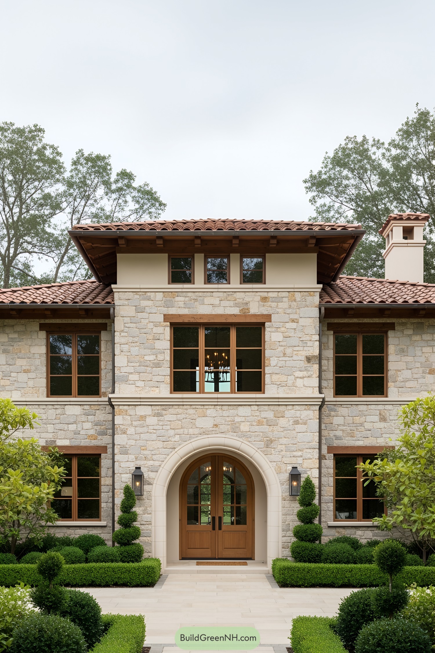 Stone house with arched wooden door and terracotta roof