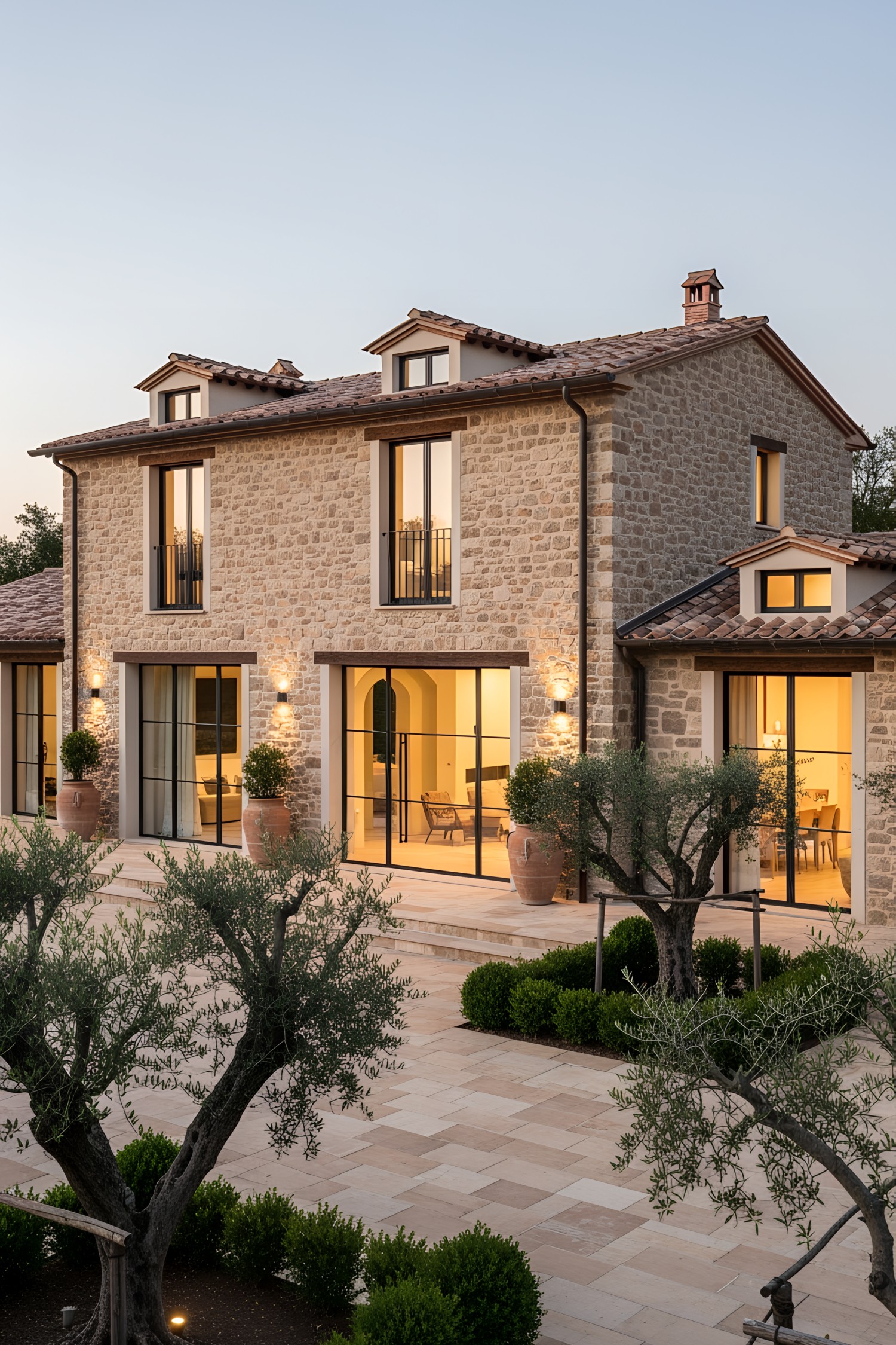 Modern Tuscan villa courtyard with stone facade and large windows