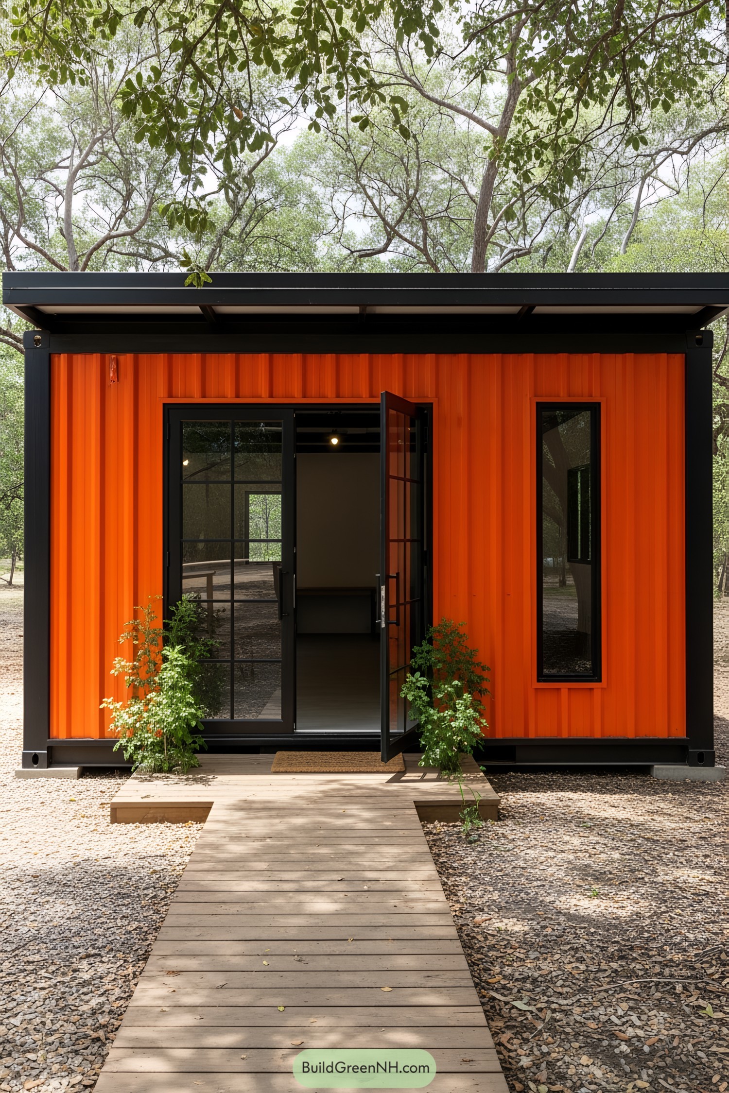 Vibrant orange shipping container workshop with a wooden walkway