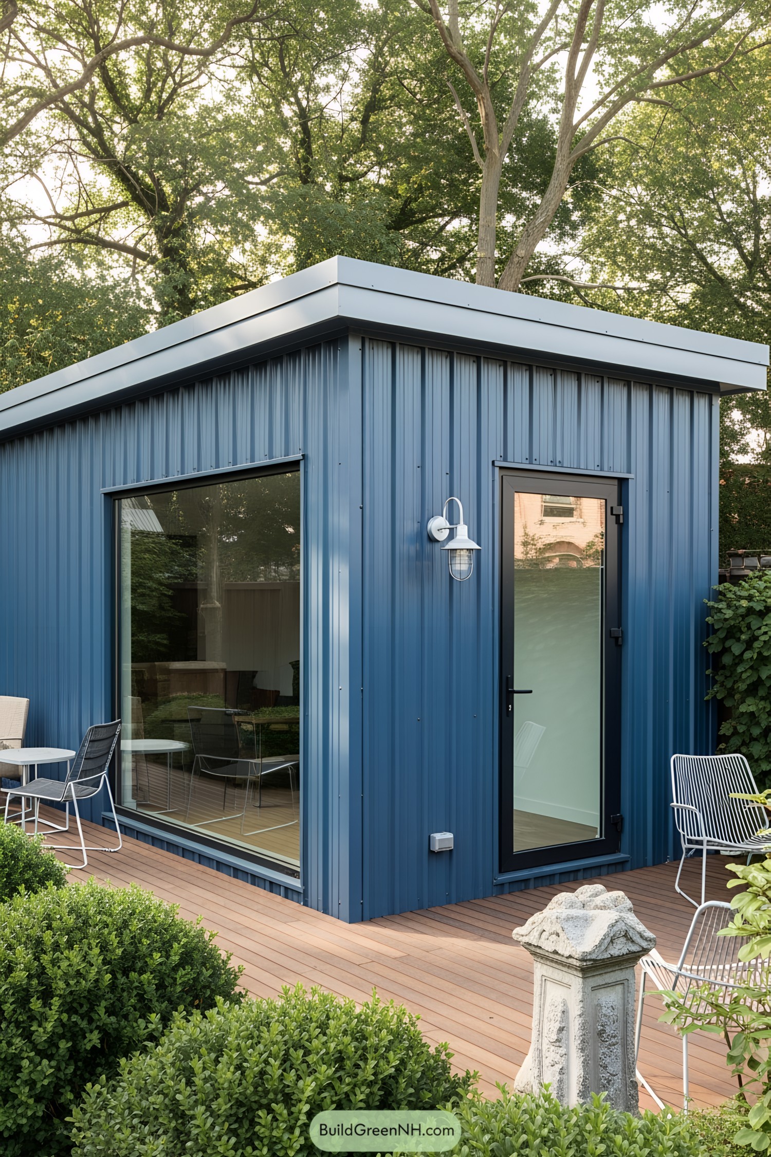 Sleek blue workshop with large windows and a cozy deck