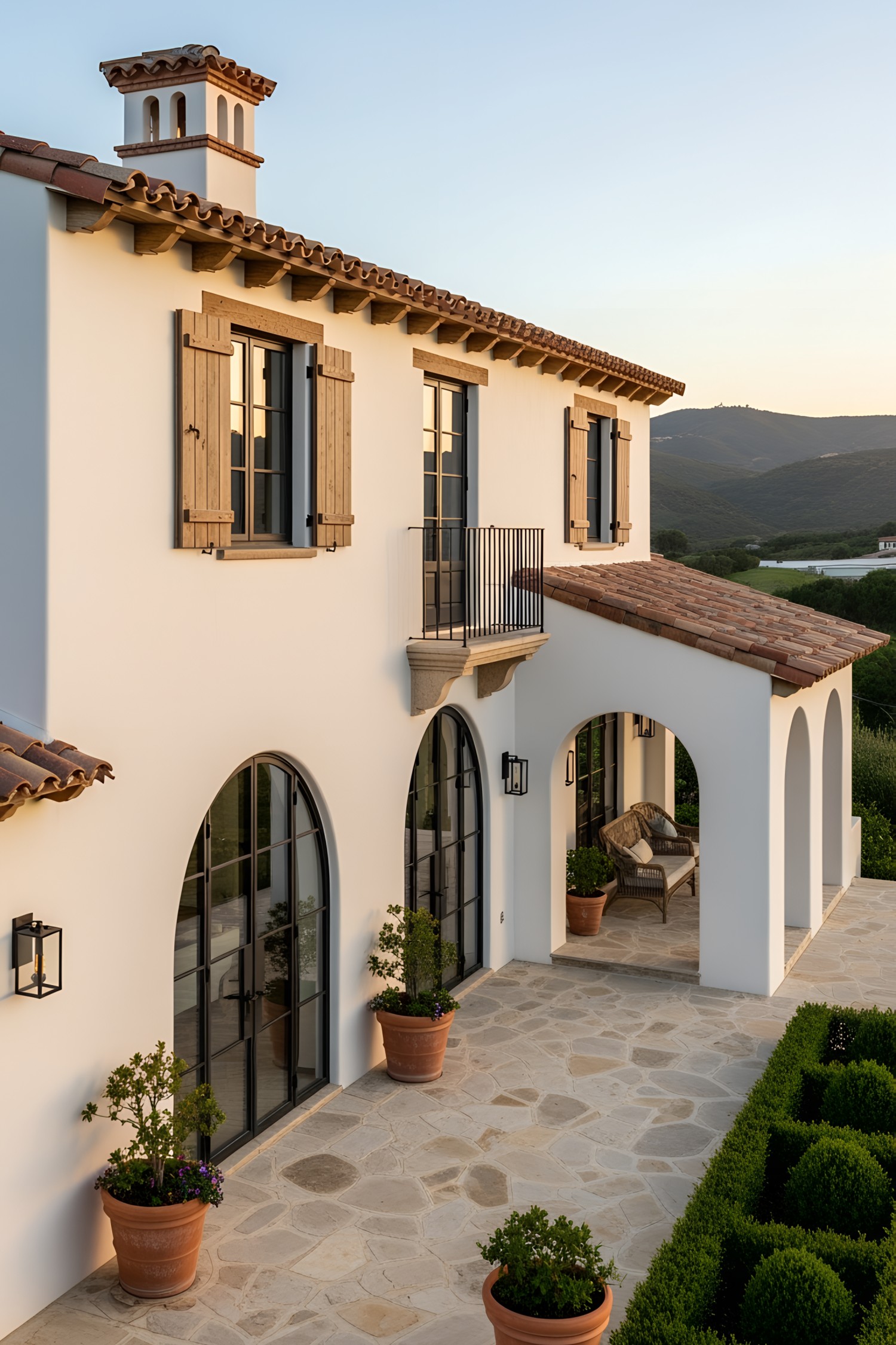Elegant coastal house with arched windows and terracotta roof