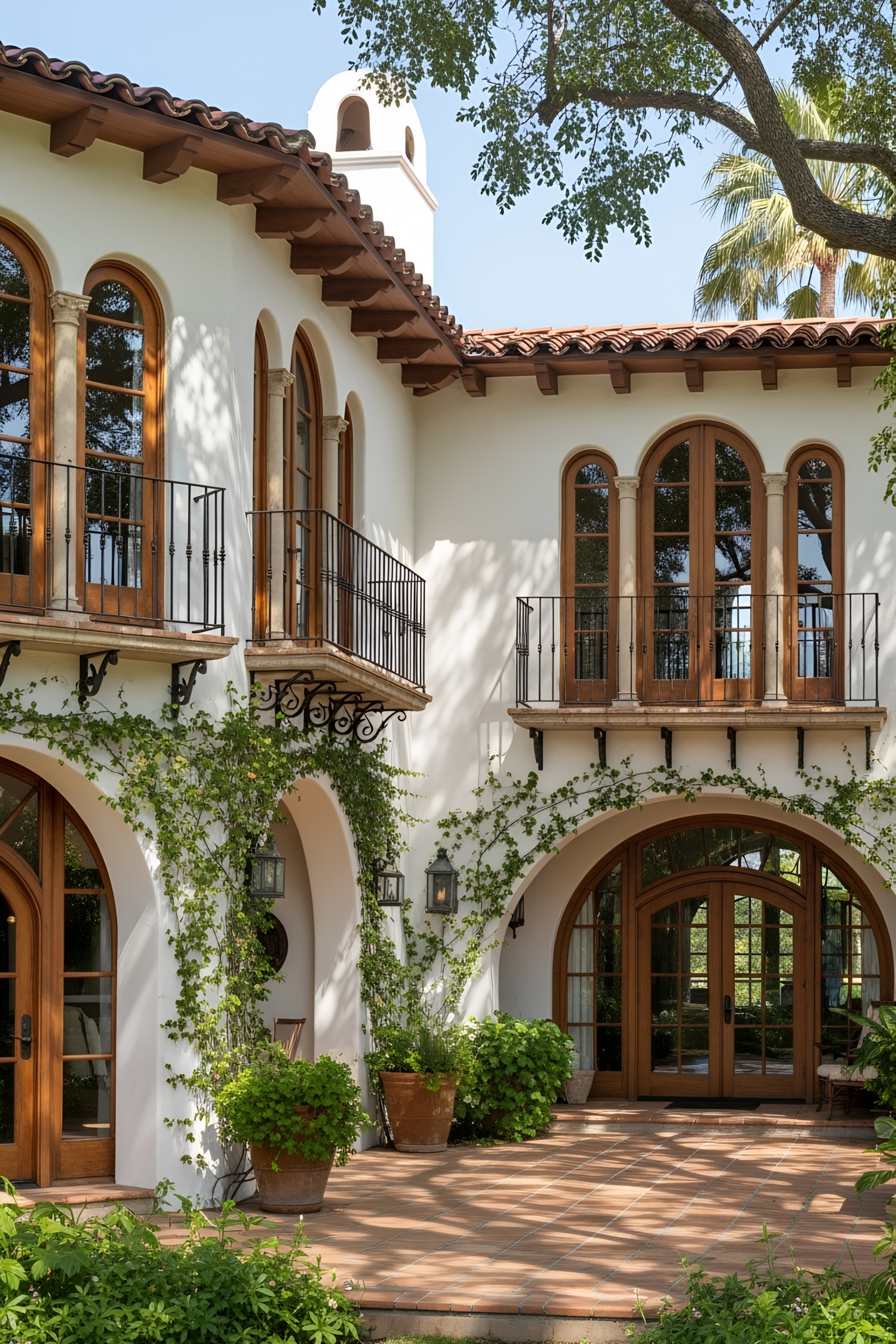 Spanish coastal house with arched windows and lush greenery