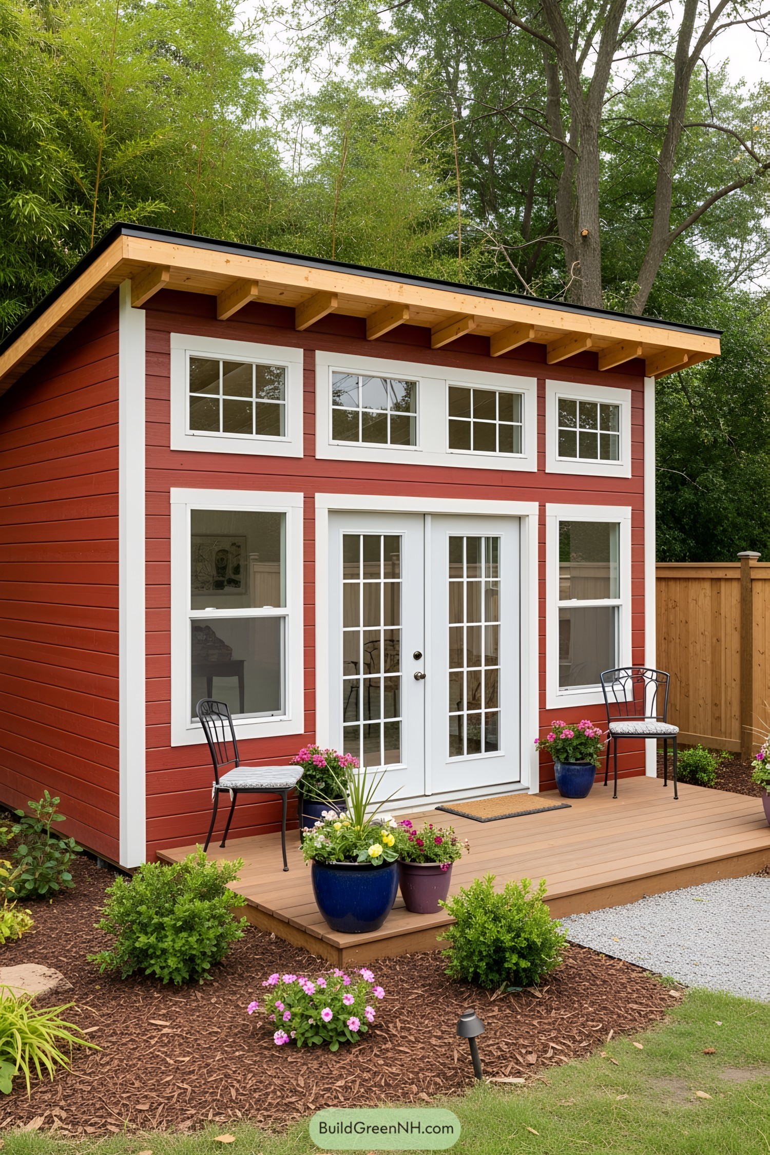 Red shed with large windows and a wooden deck