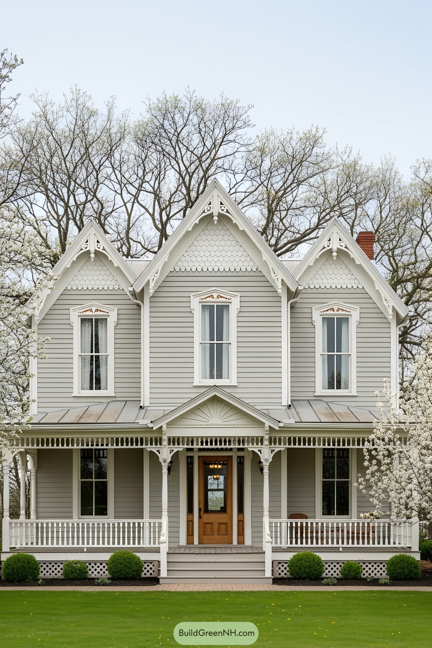 Charming gray Victorian house with gables and white intricate trims