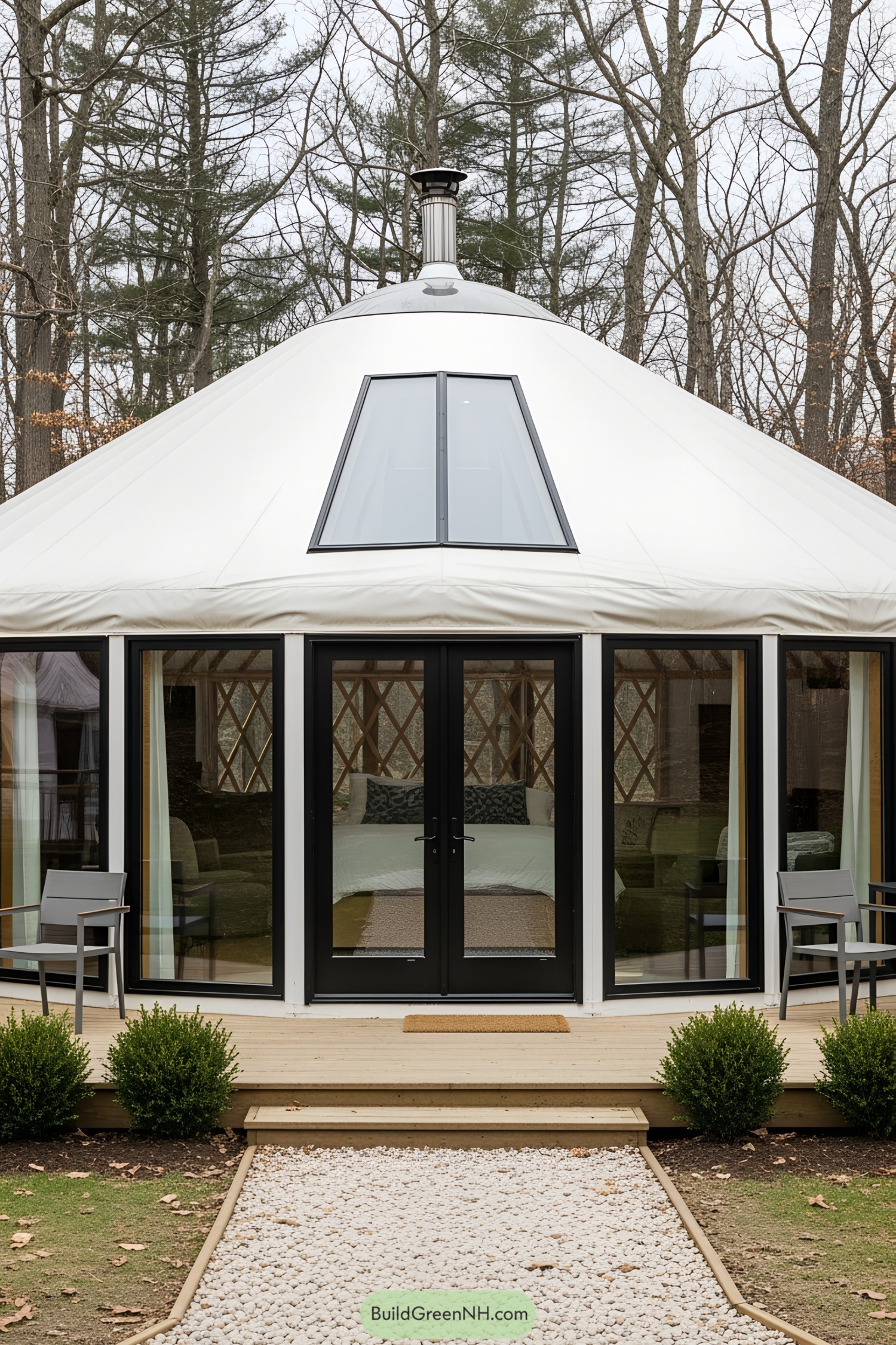 Modern yurt with glass doors and deck, nestled among trees