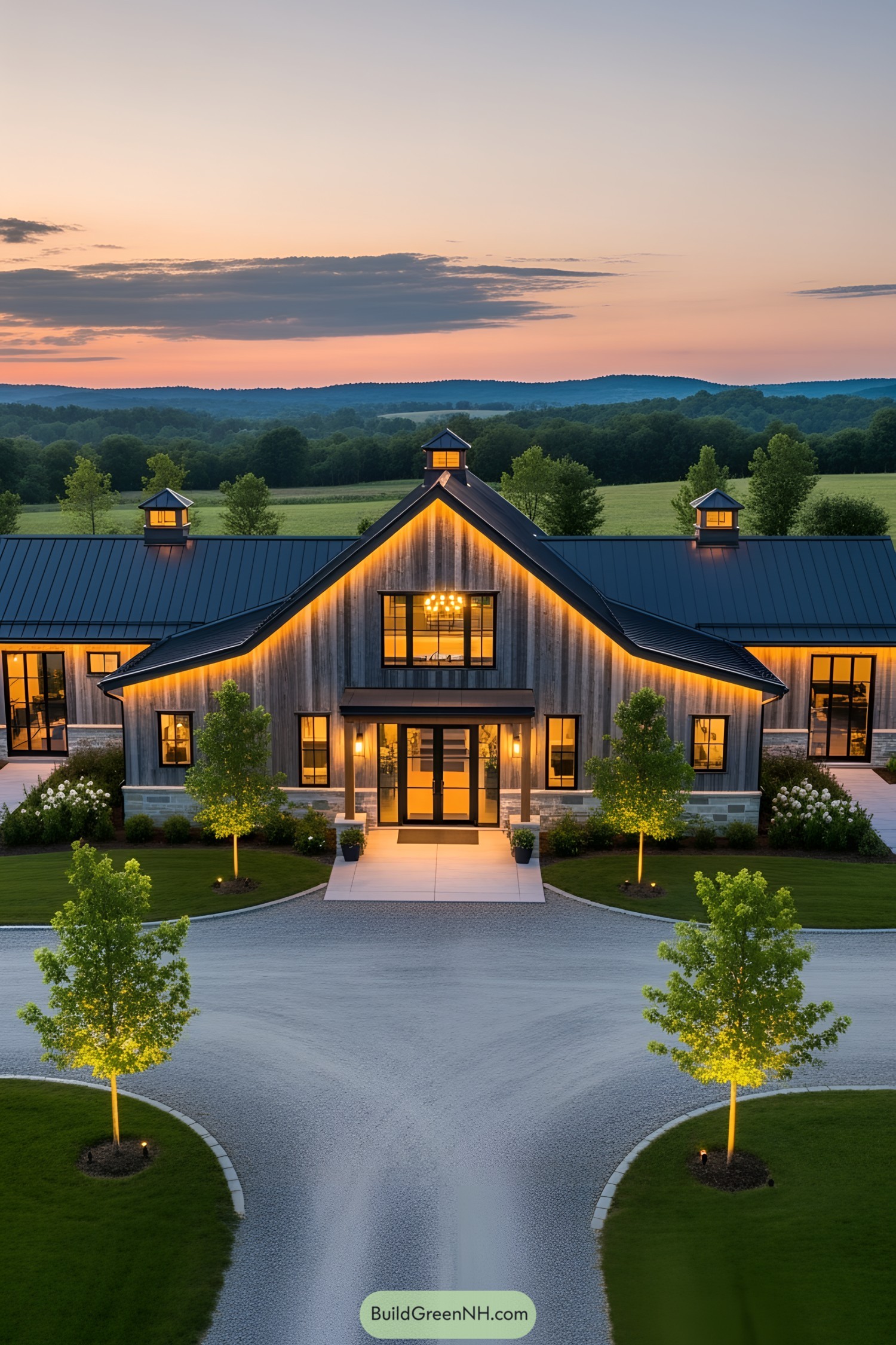 A modern barndominium lit with LED lights at sunset, surrounded by trees
