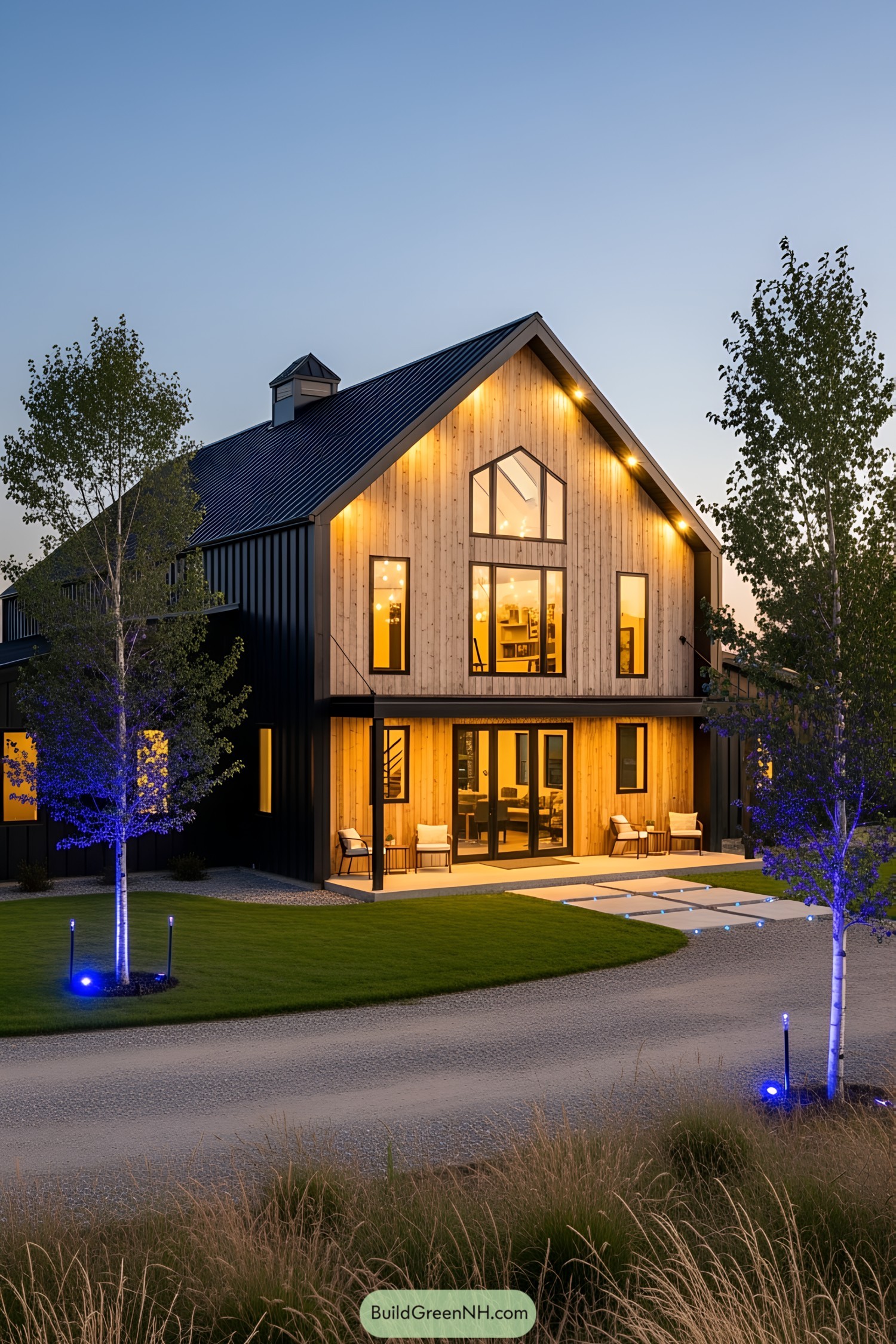 Modern barndominium with LED lights and trees at sunset