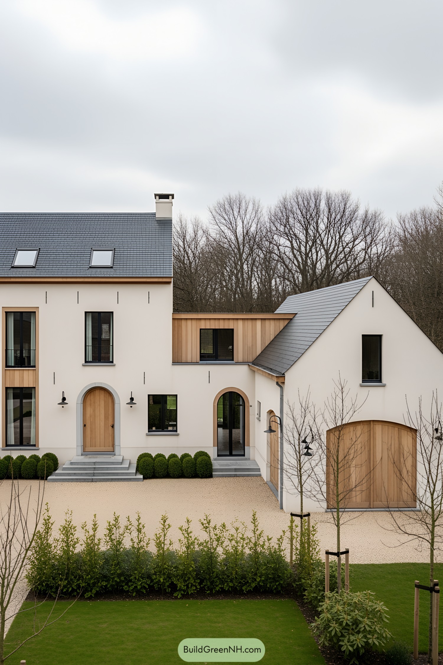 Elegant farmhouse with arched wooden doors and manicured shrubs