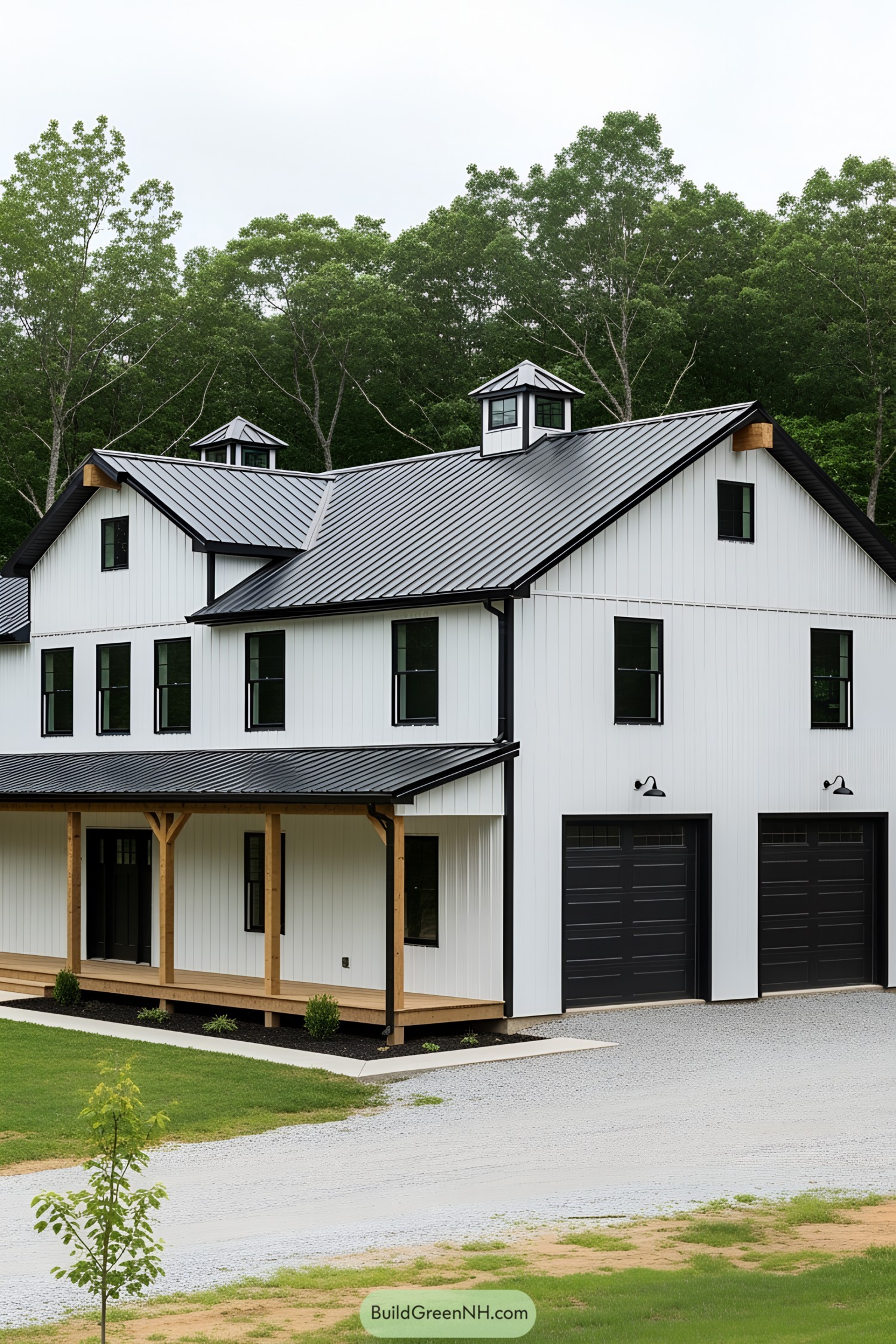 Black and white barndominium with lush greenery backdrop