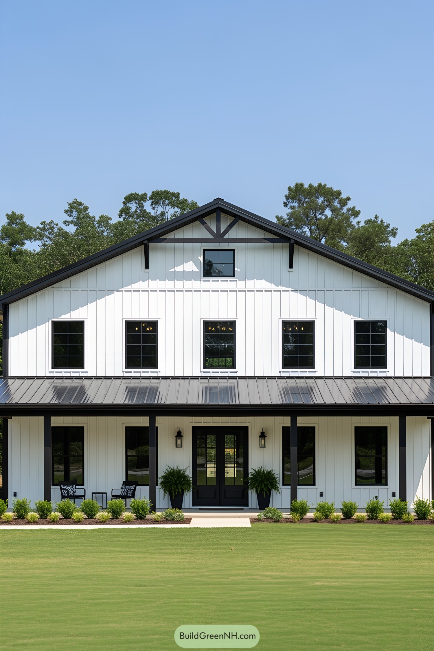 Black and white barndominium with large windows and a sleek metal roof