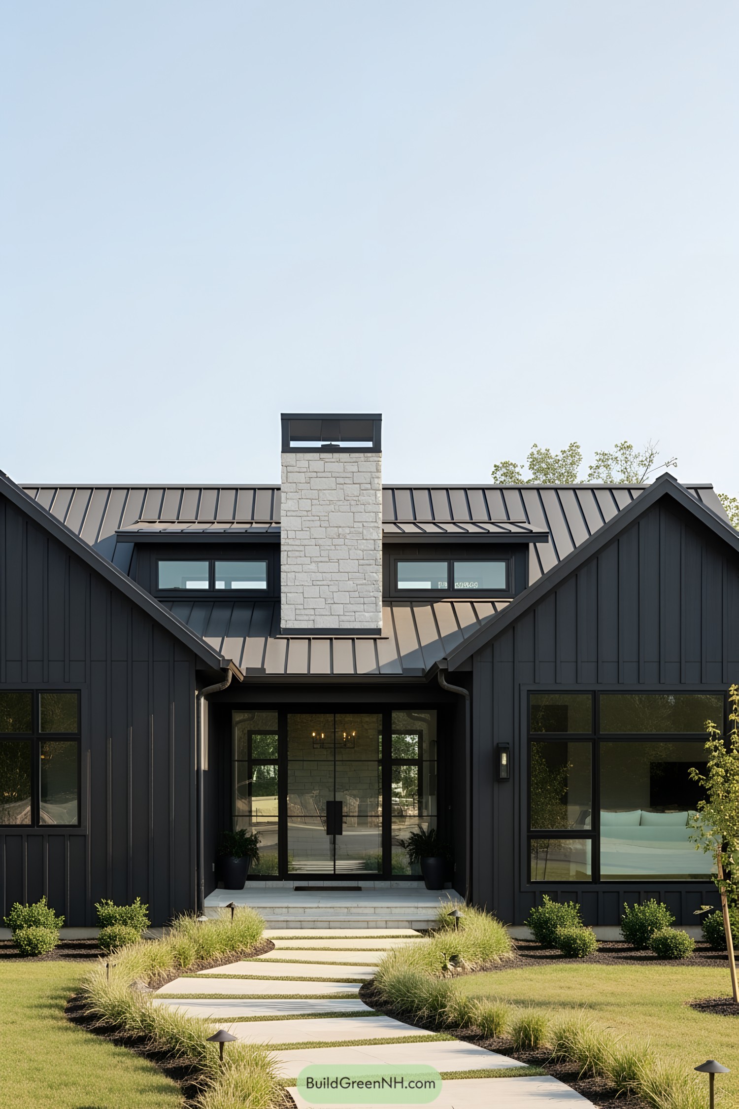 Sleek black ranch house with a stone chimney and modern landscaping
