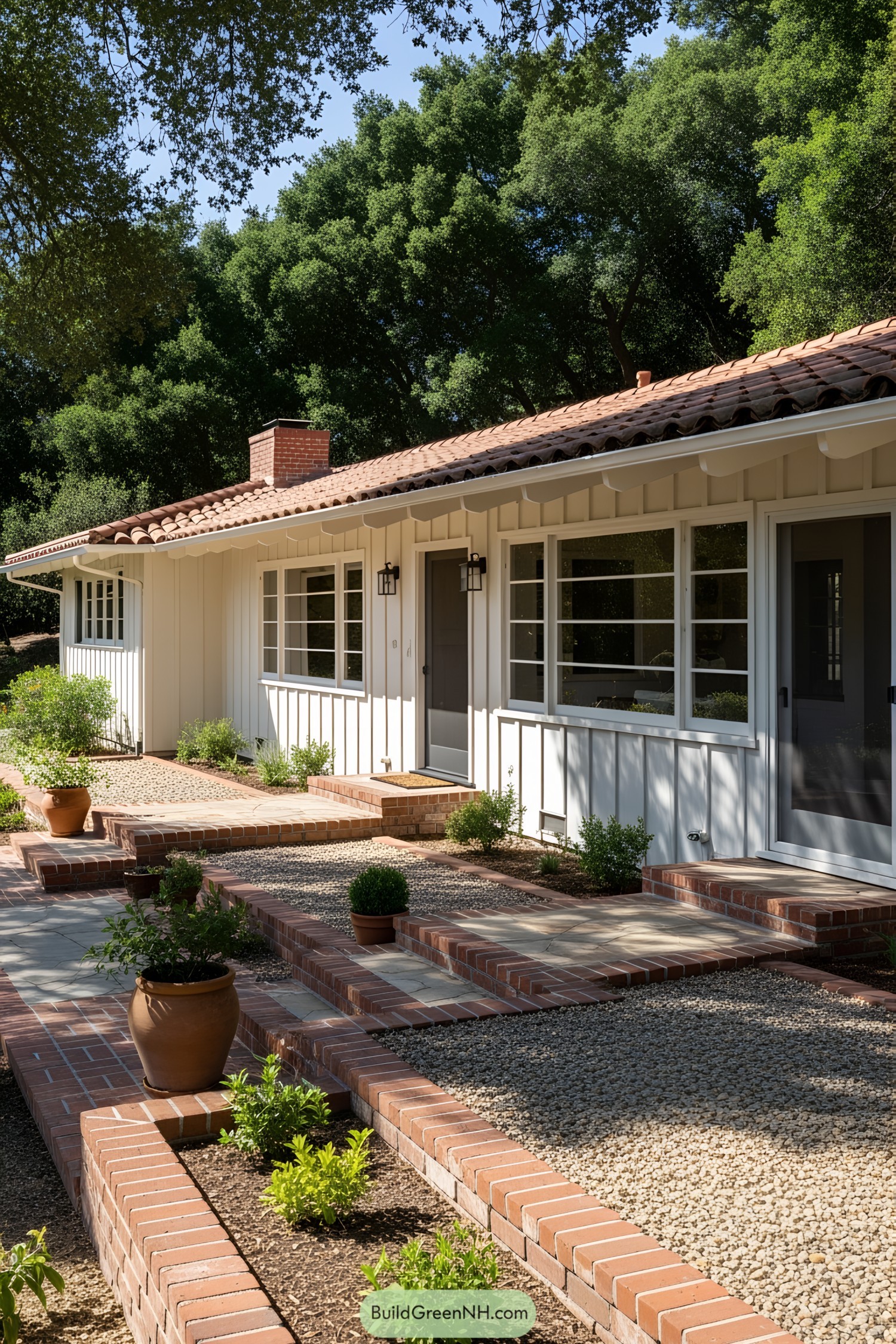 White ranch house with red roof and brick walkways